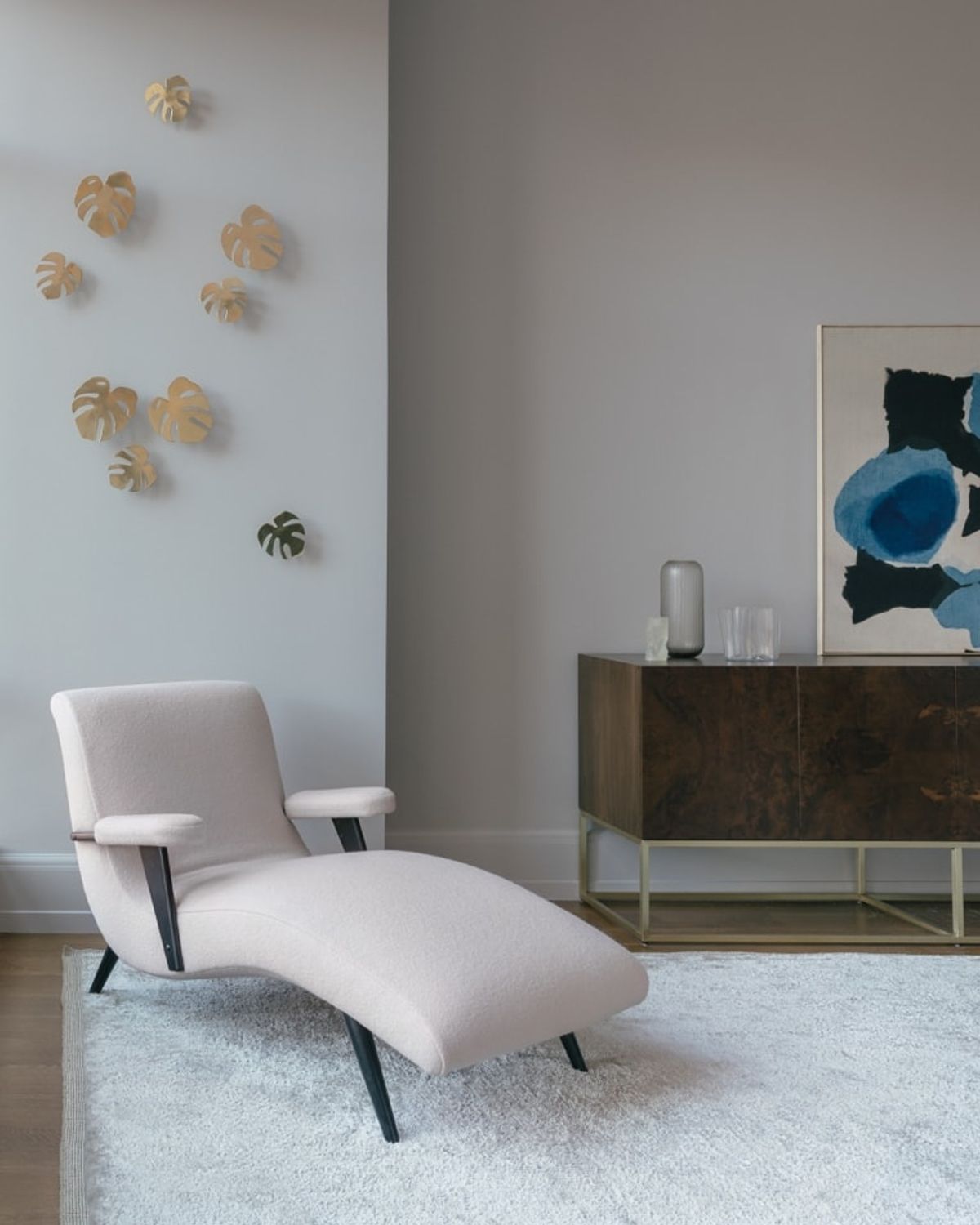 Cream-colored chaise with artwork in the background
