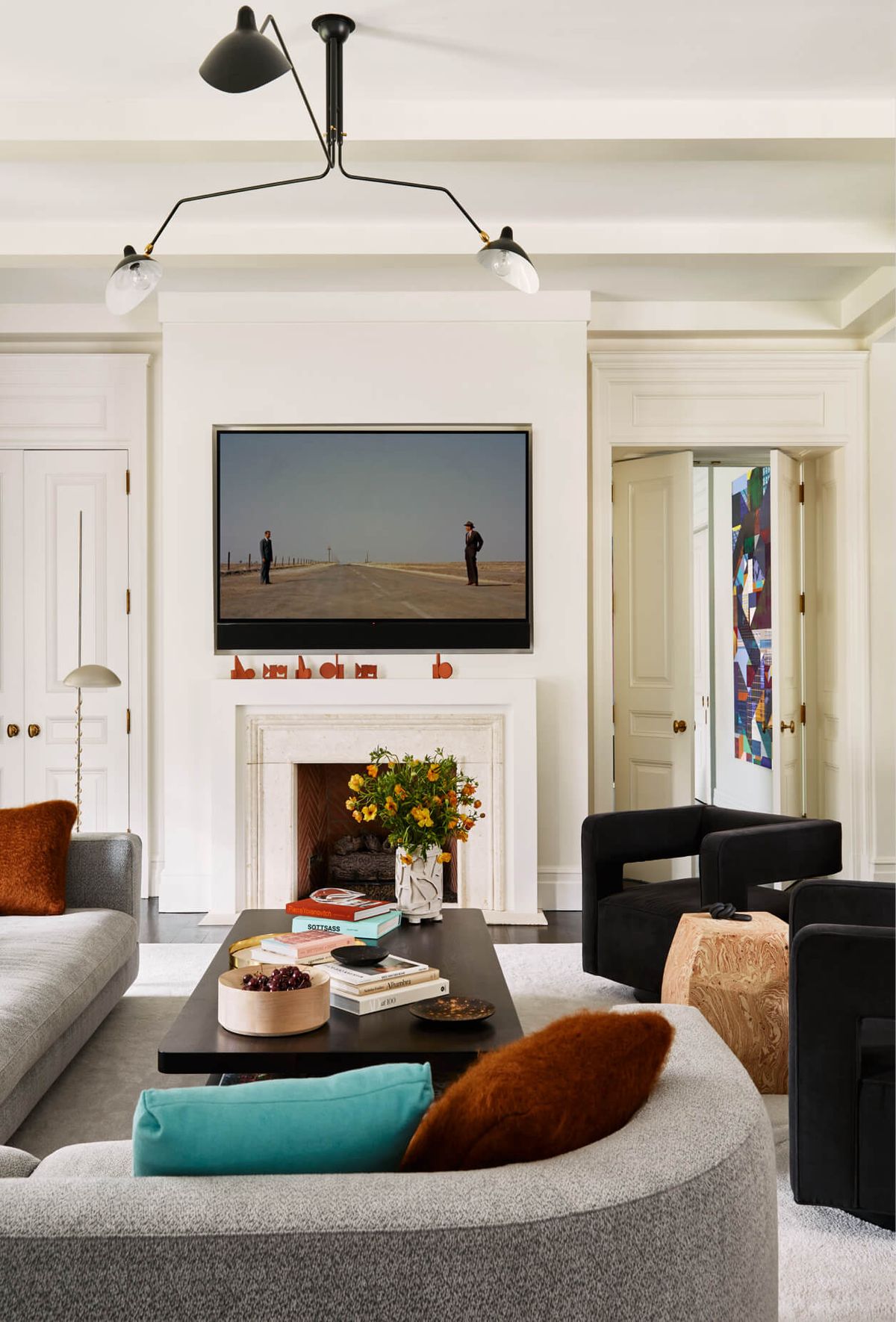 Secondary sitting room with gray sofa, coffee table, chairs and fireplace