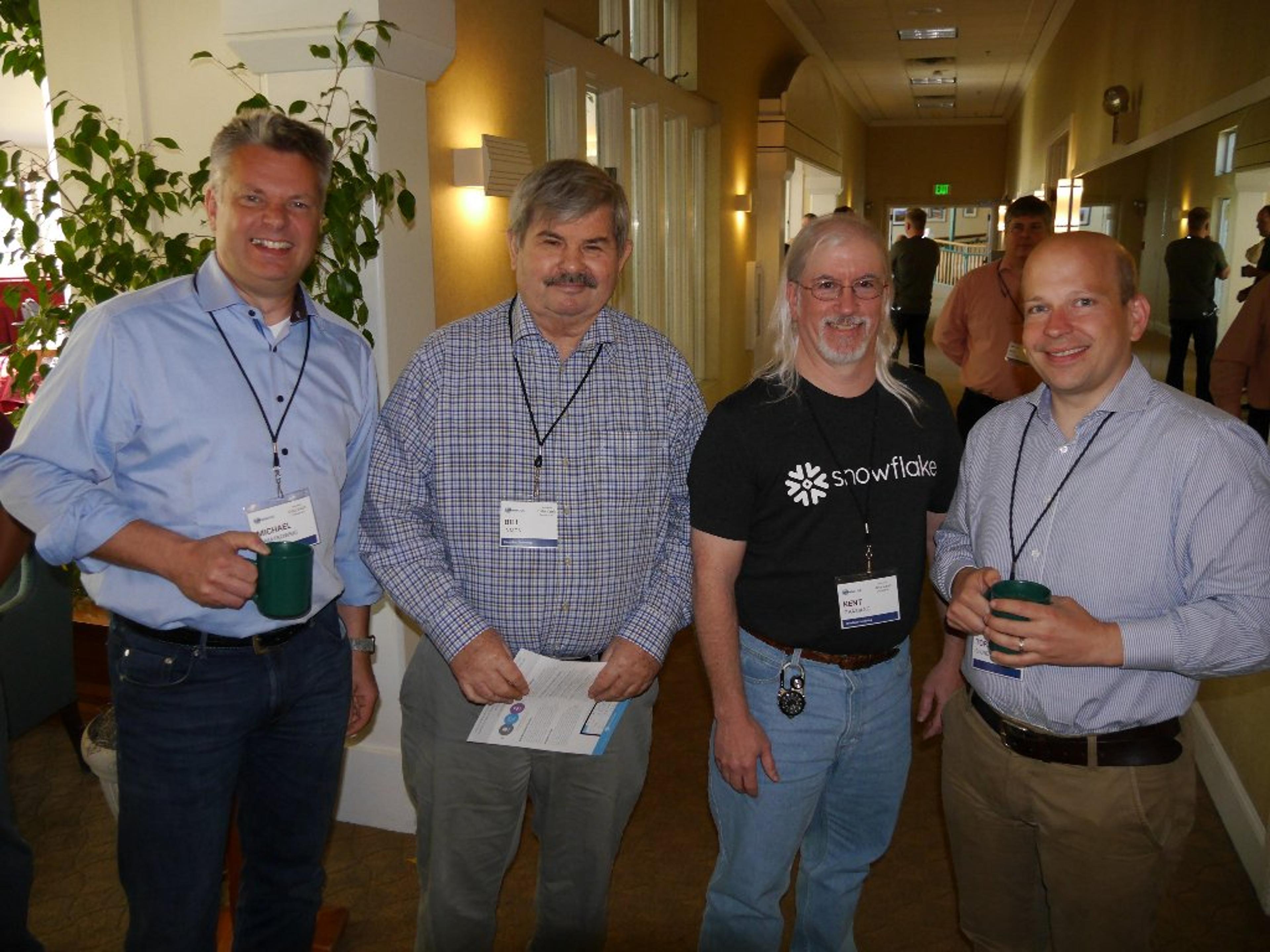 A group of men wearing name tags and standing in a hallway.