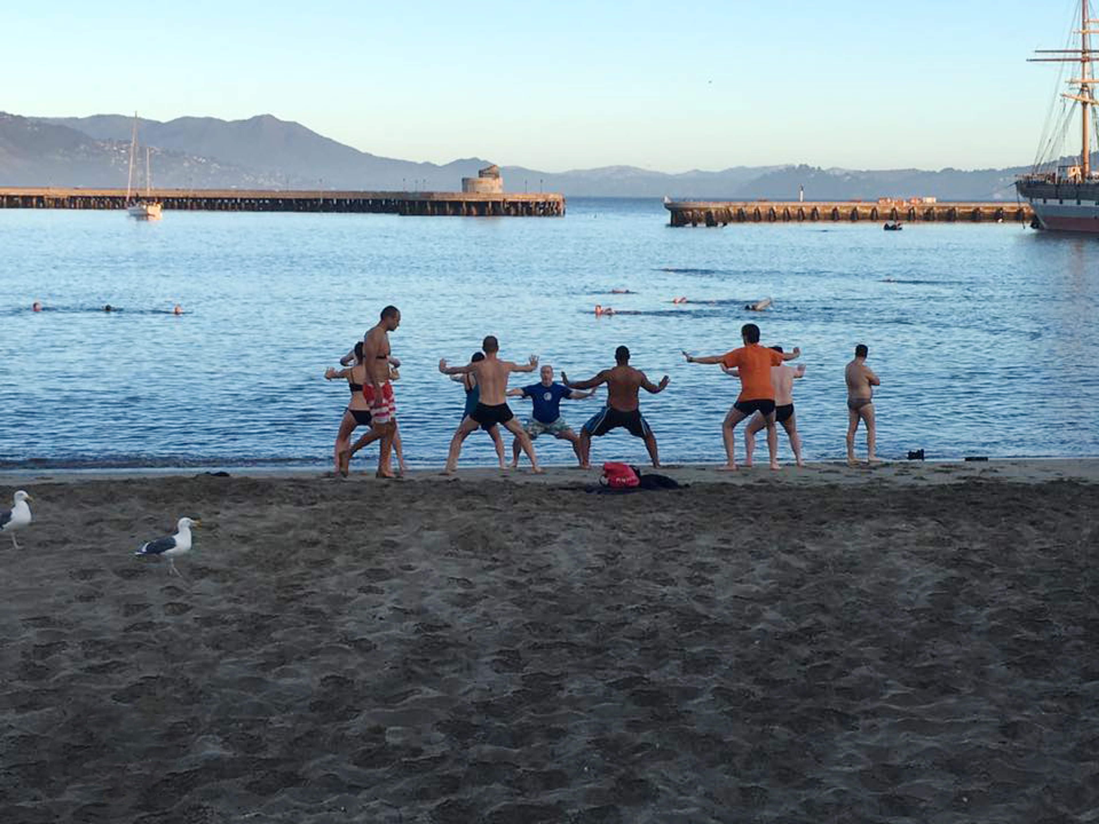 A group of people are doing yoga on the beach.