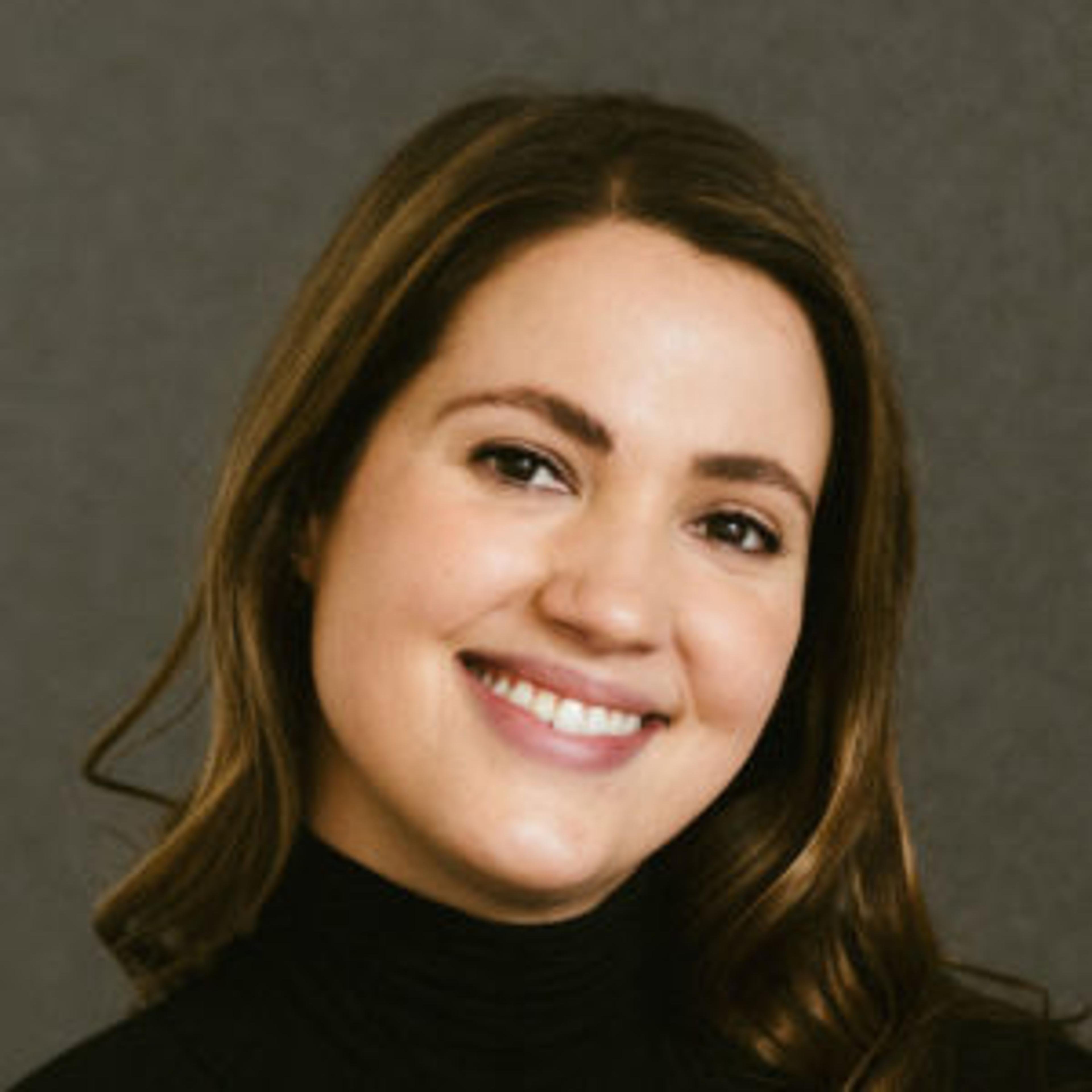 A woman wearing a black shirt smiling.