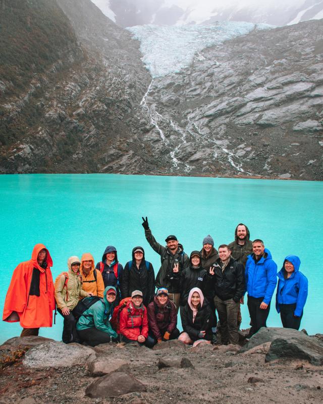 A group of people posing for a picture in front of a large body of water.