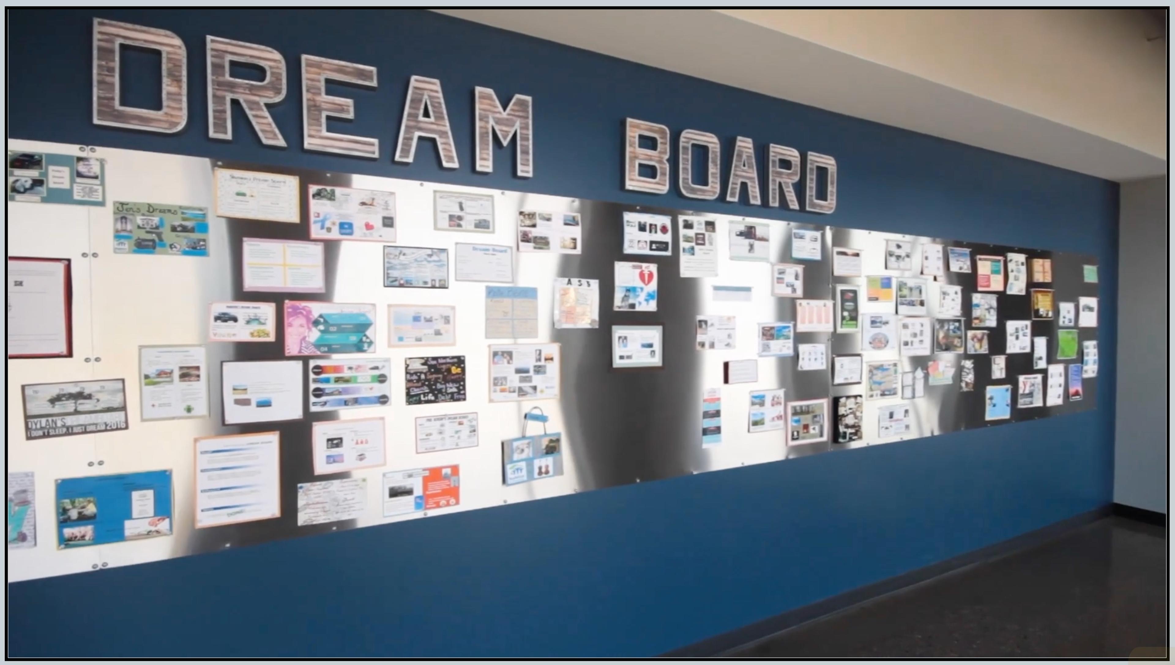 A "Dream Board" wall in Delta Defense's office, covered with employees' personal goal collages