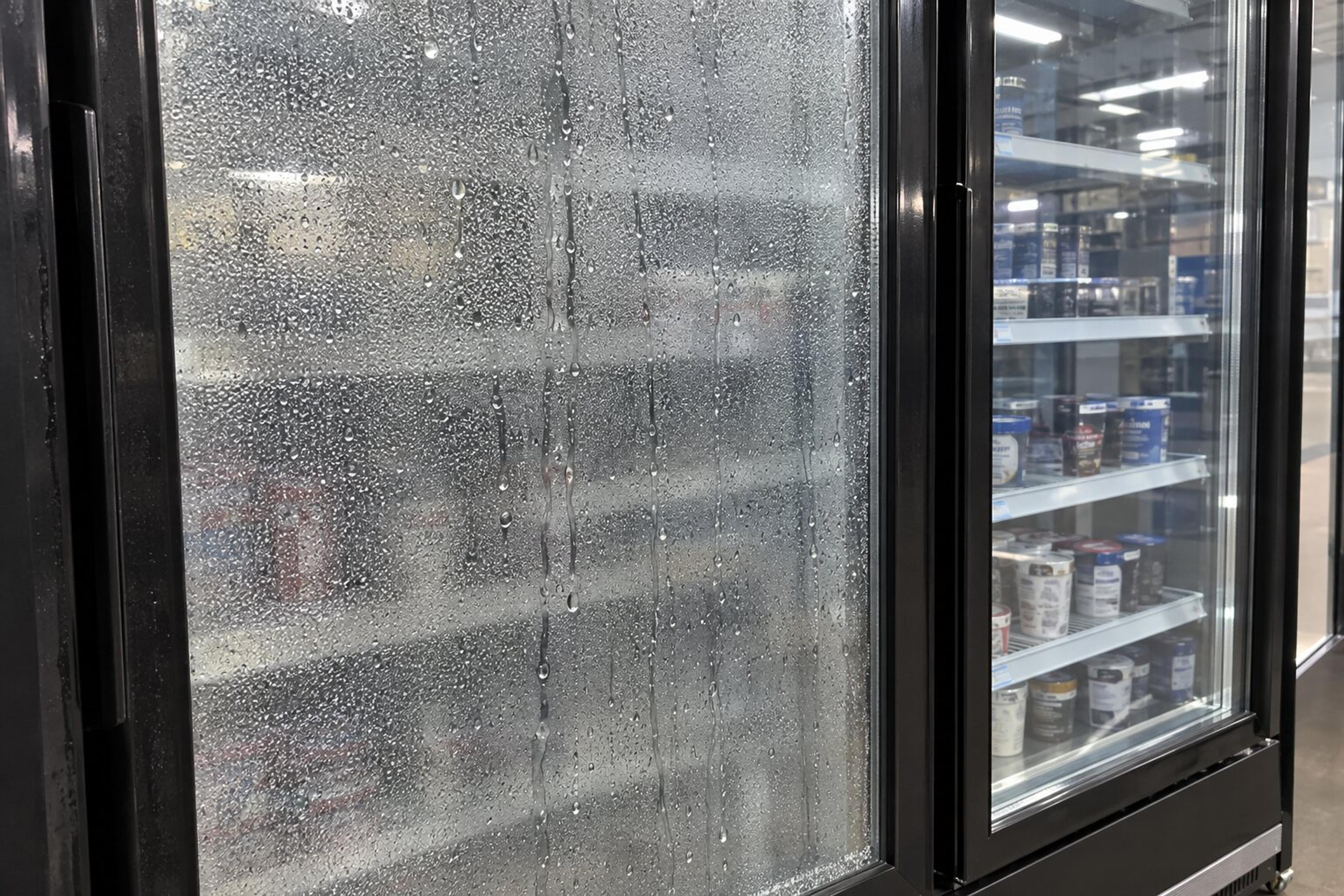 Fogged freezer glass door next to a clear heated glass door