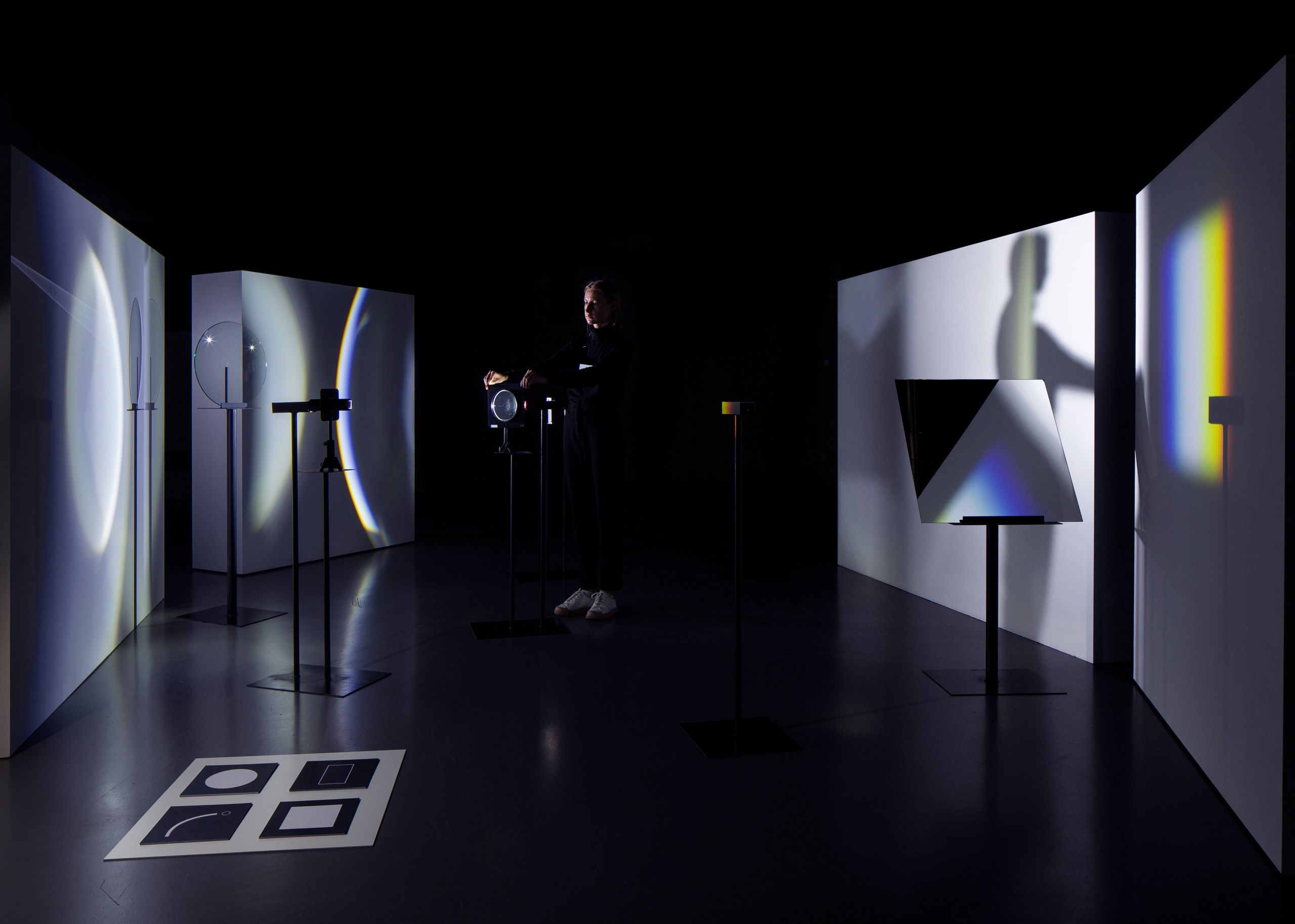 Projet de diplôme master design espace et communication alexandra hofmann, femme utilisant outils transparents ou des miroirs pour produire des reflets avec le spectre lumineux