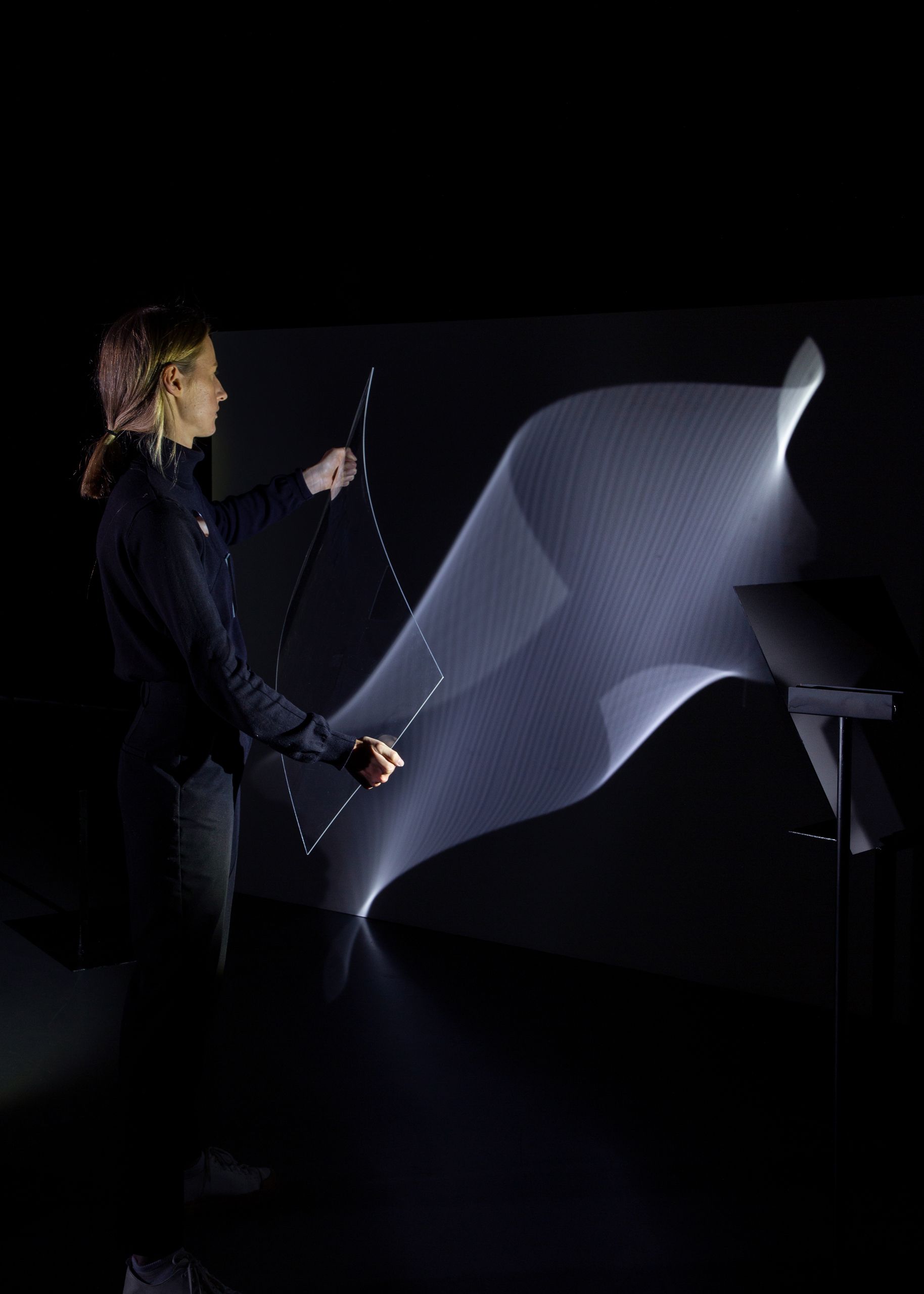 Projet de diplôme master design espace et communication alexandra hofmann, femme utilisant outils transparents ou des miroirs pour produire des reflets avec le spectre lumineux