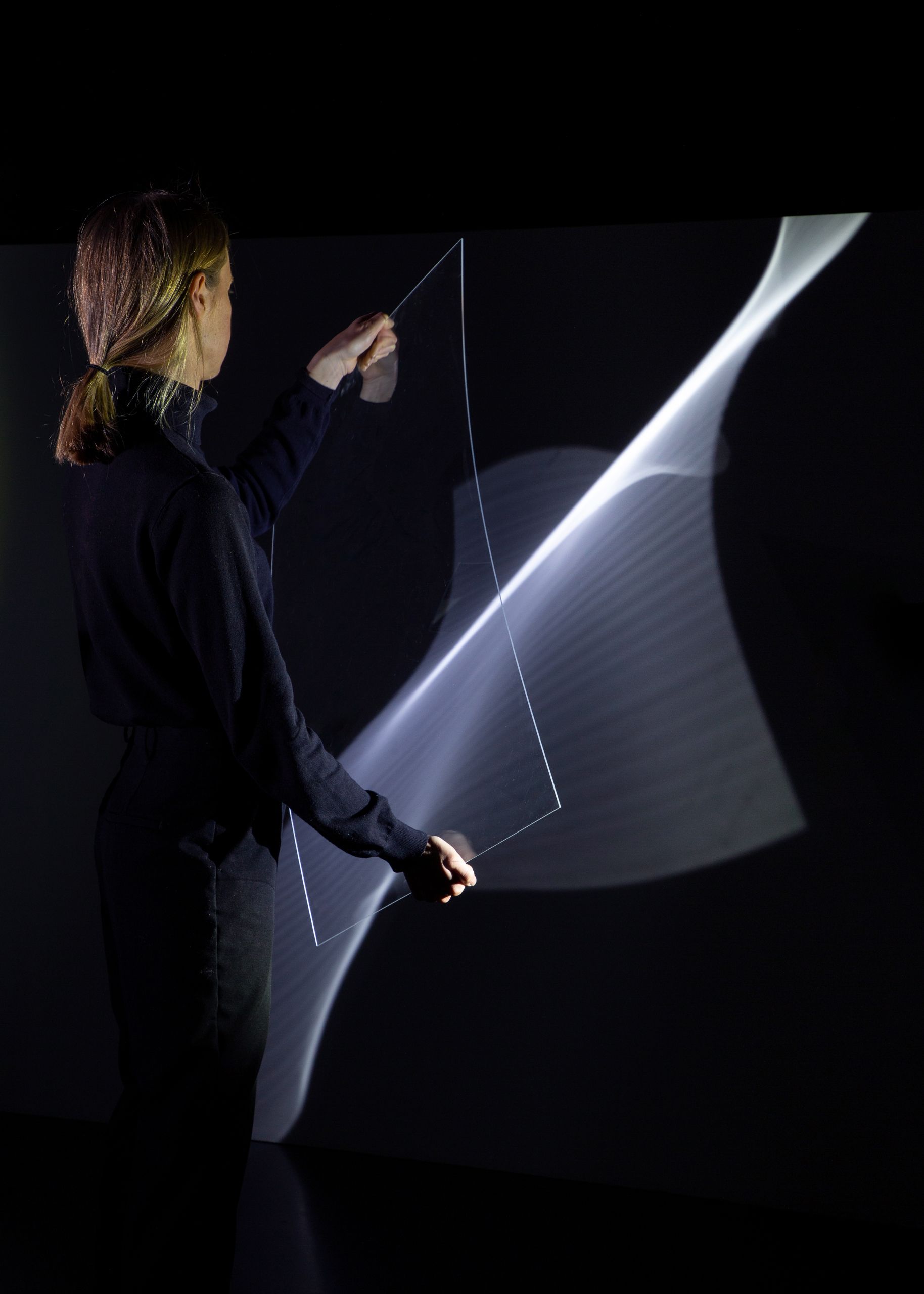 Projet de diplôme master design espace et communication alexandra hofmann, femme utilisant outils transparents ou des miroirs pour produire des reflets avec le spectre lumineux
