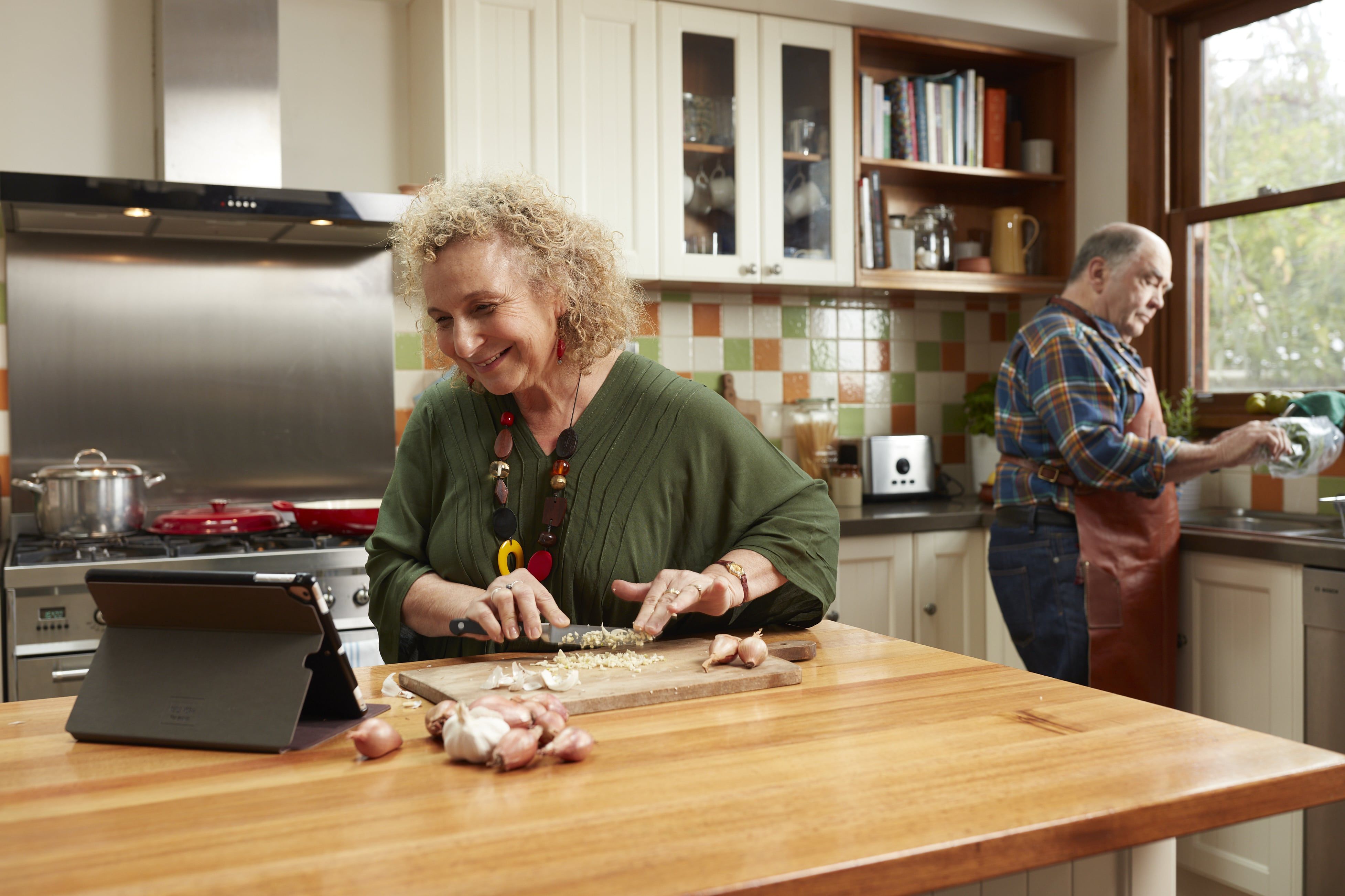 An older couple cooking together in their kitchen