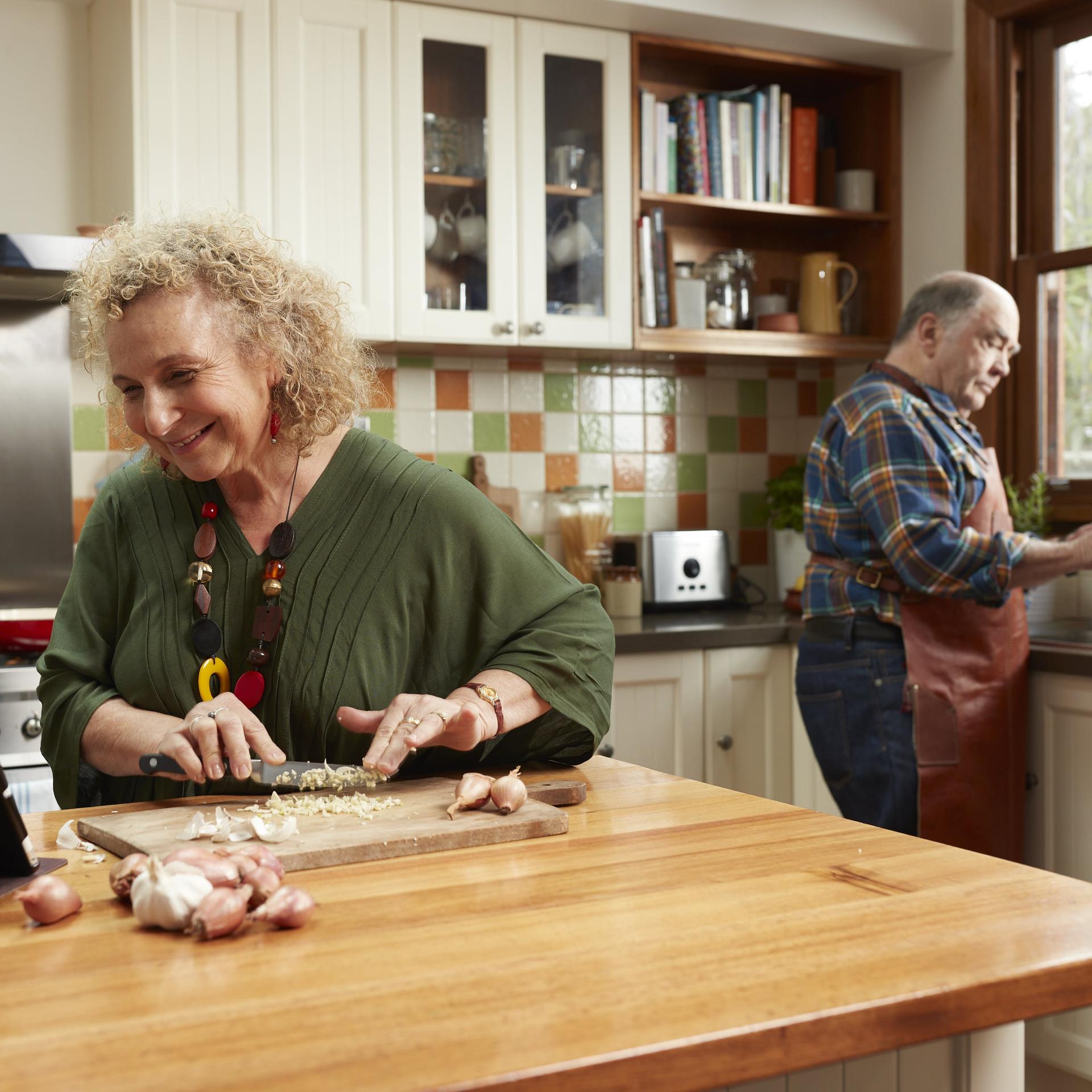 An older couple cooking together in their kitchen