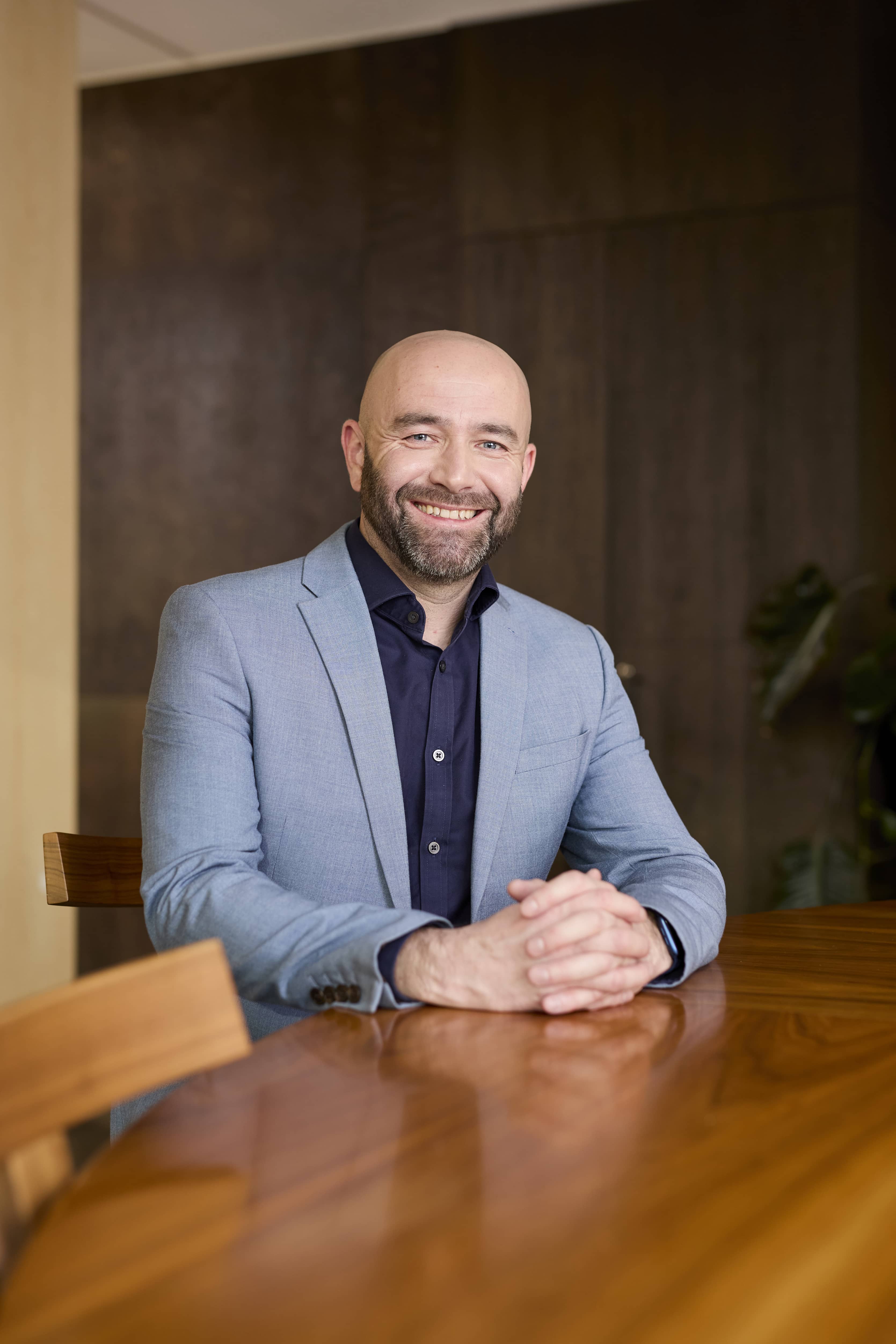 Man sitting behind a wooden table in an office