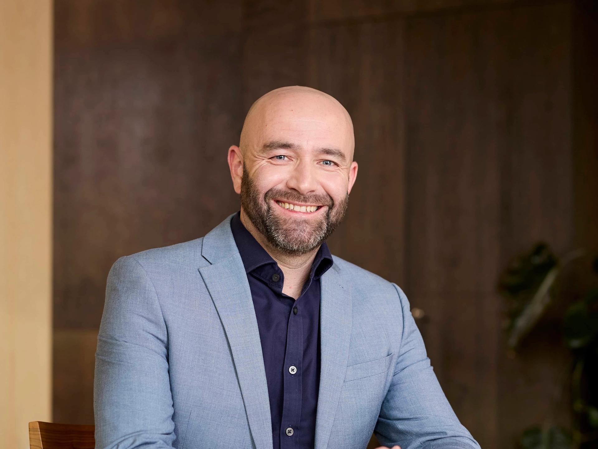 Man sitting behind a wooden table in an office