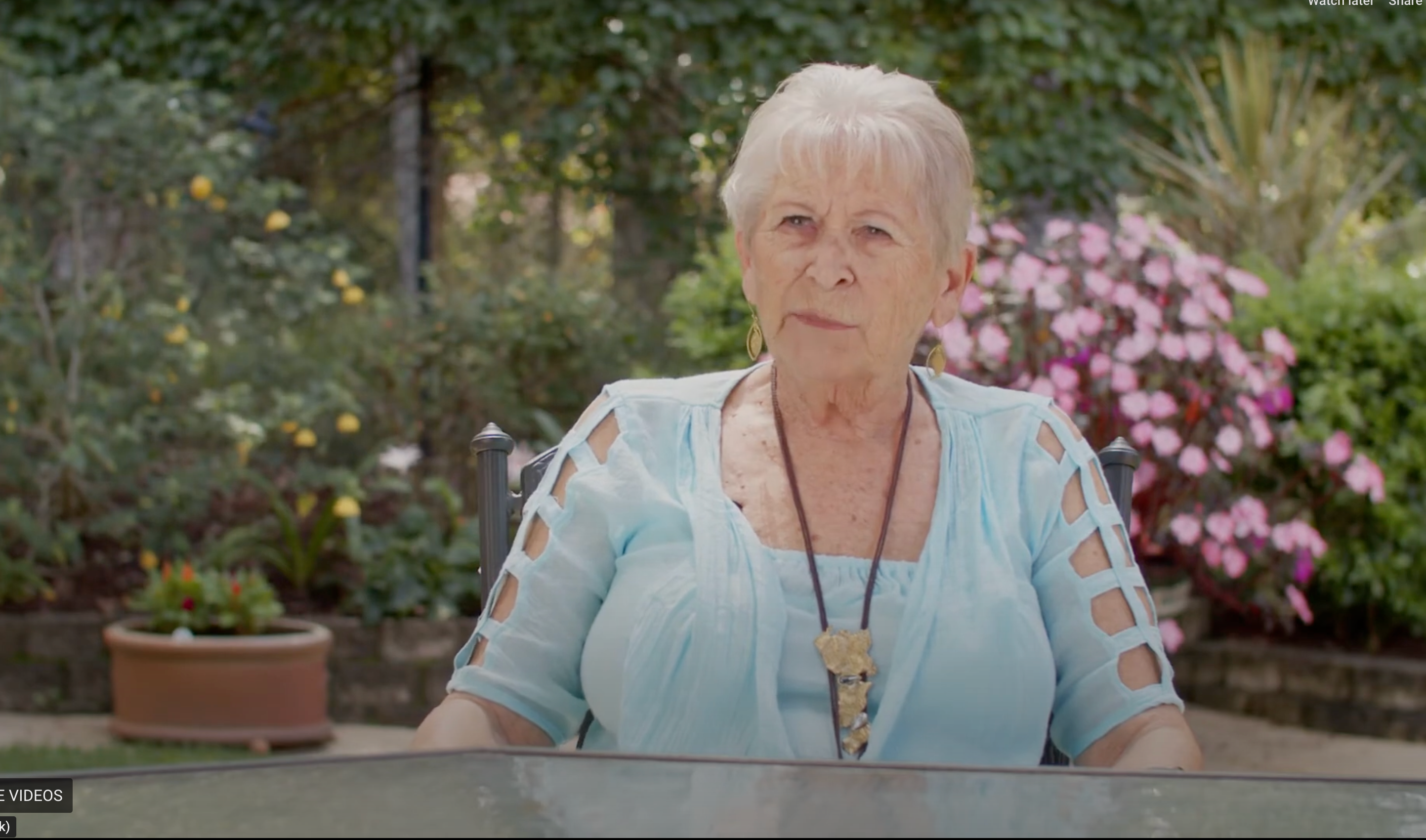 A woman sitting at a table in a garden