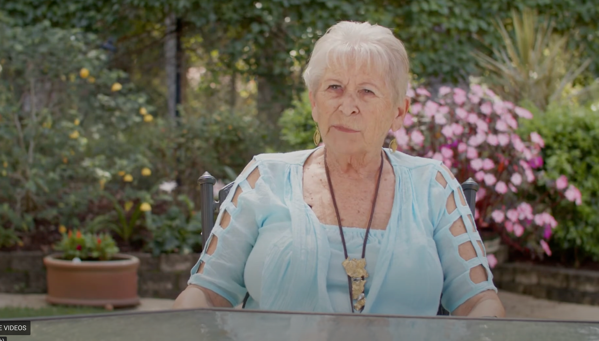 A woman sitting at a table in a garden