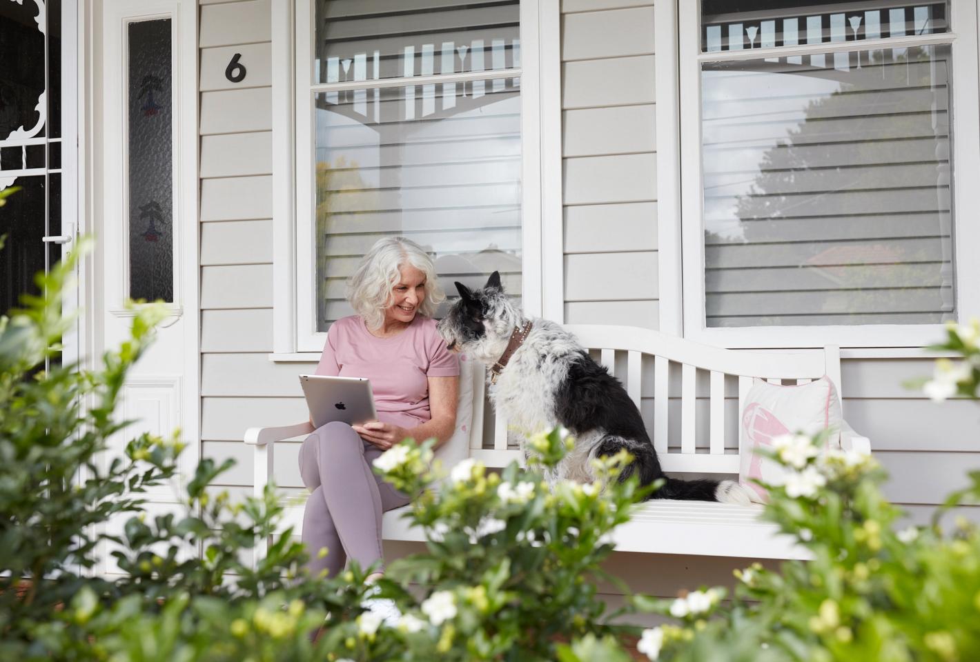 Woman siting on bench looking at a dog