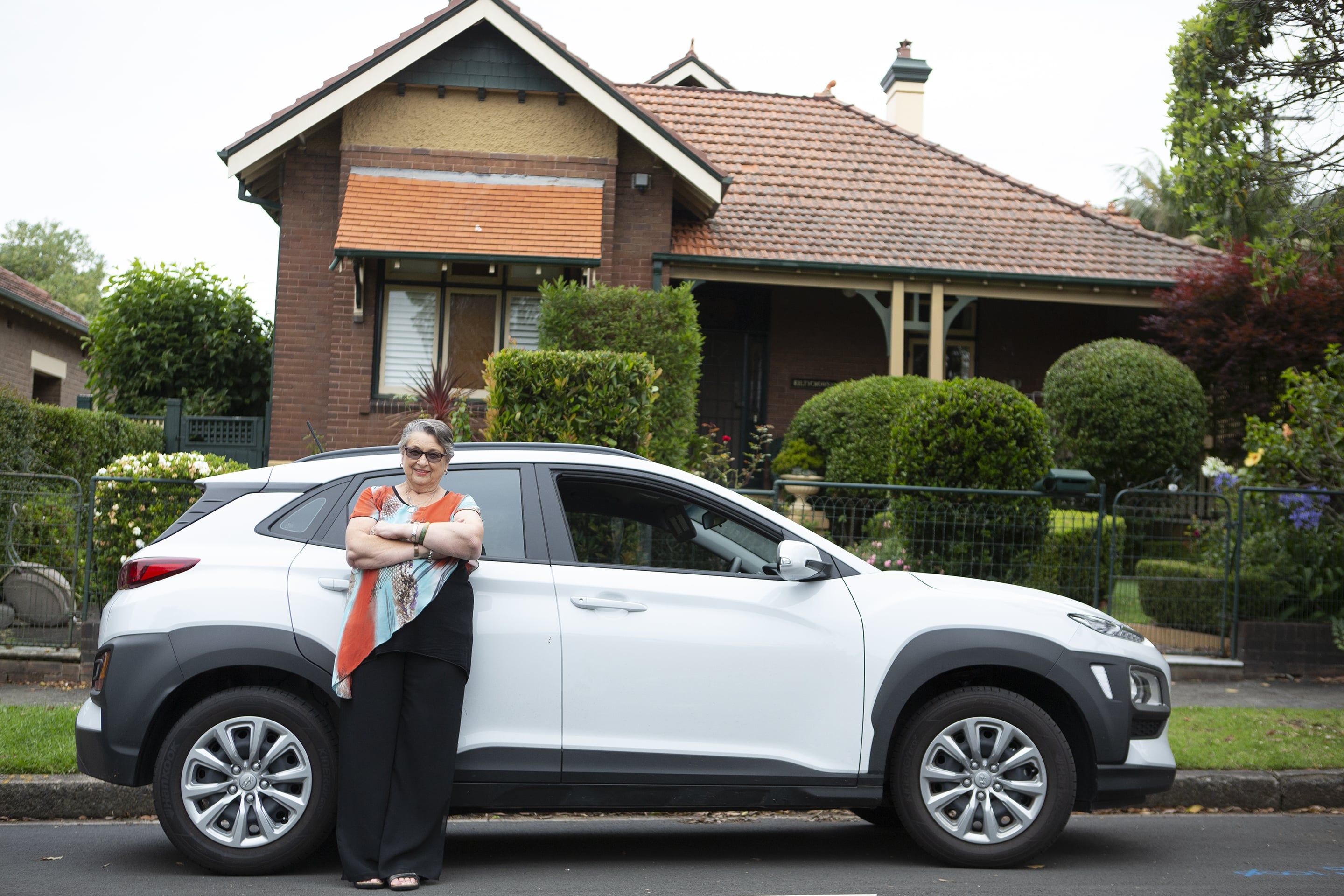 Household Capital customers Lynne standing proudly in front of her new white car