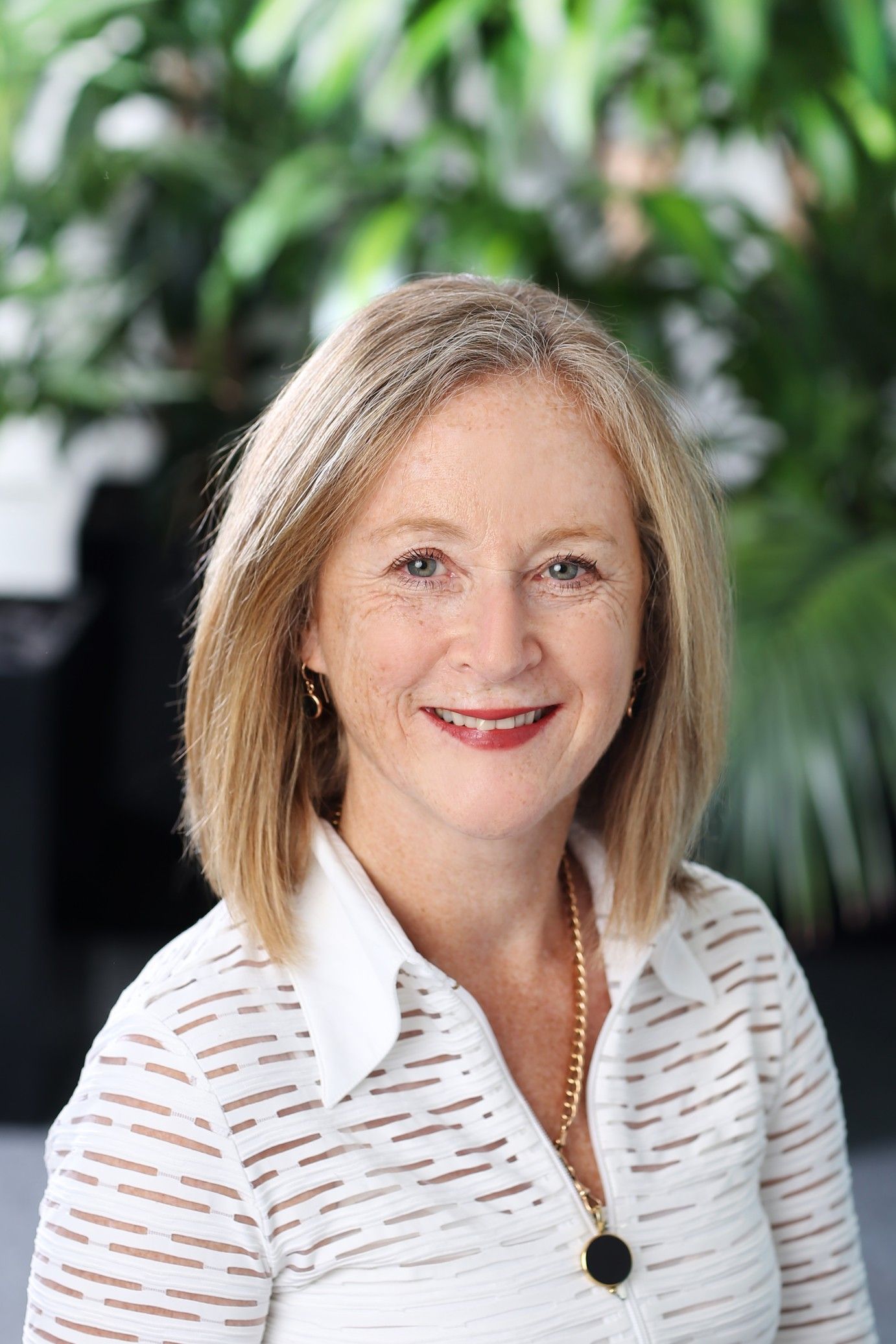 Woman standing in front of green plant