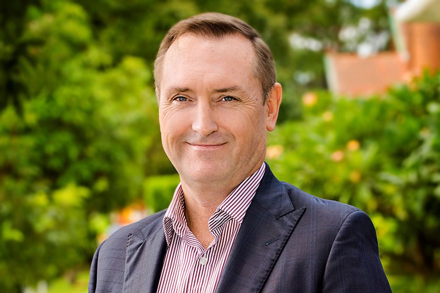 Man smiling in front of a blue background