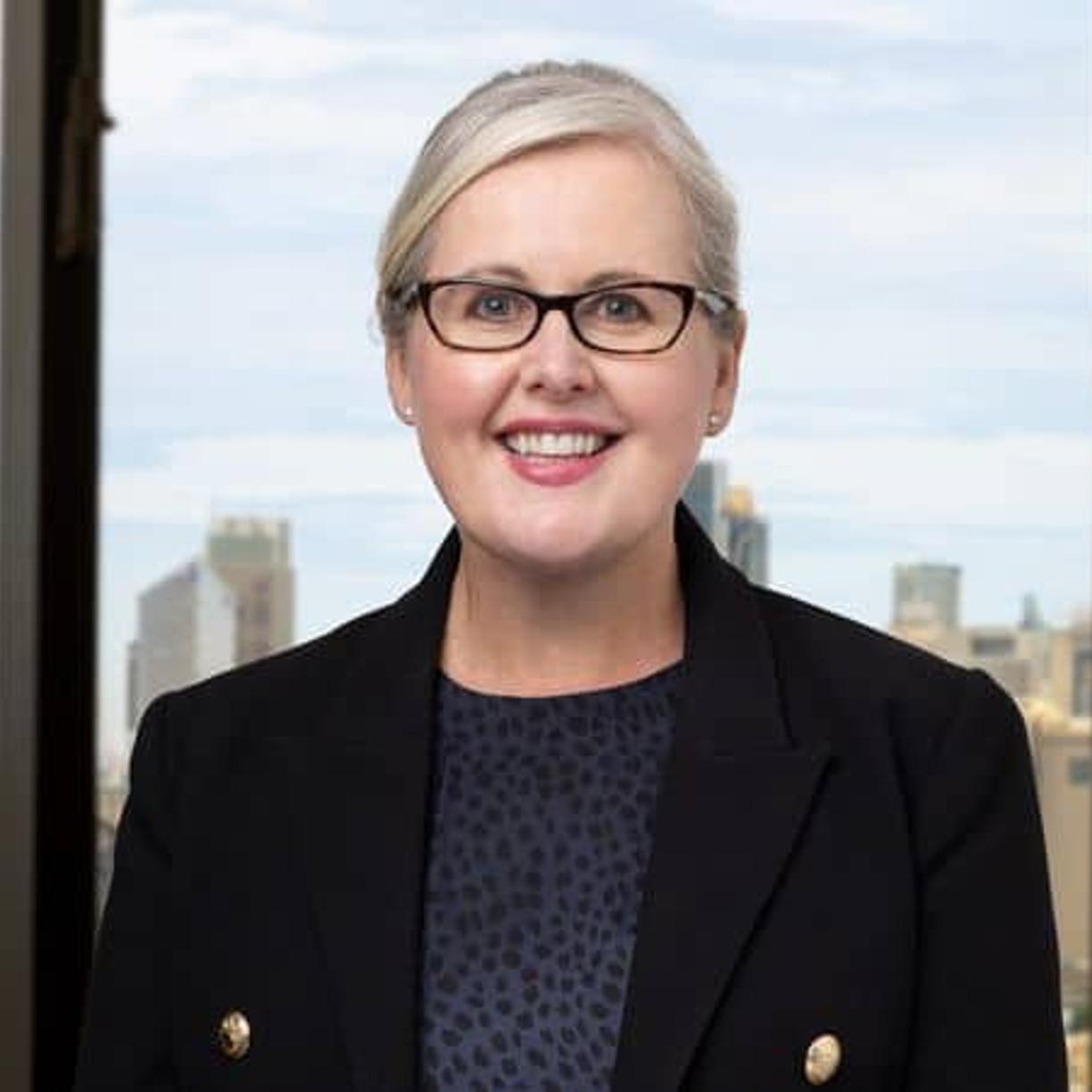 Woman standing in front of a window looking out on the Sydney harbour