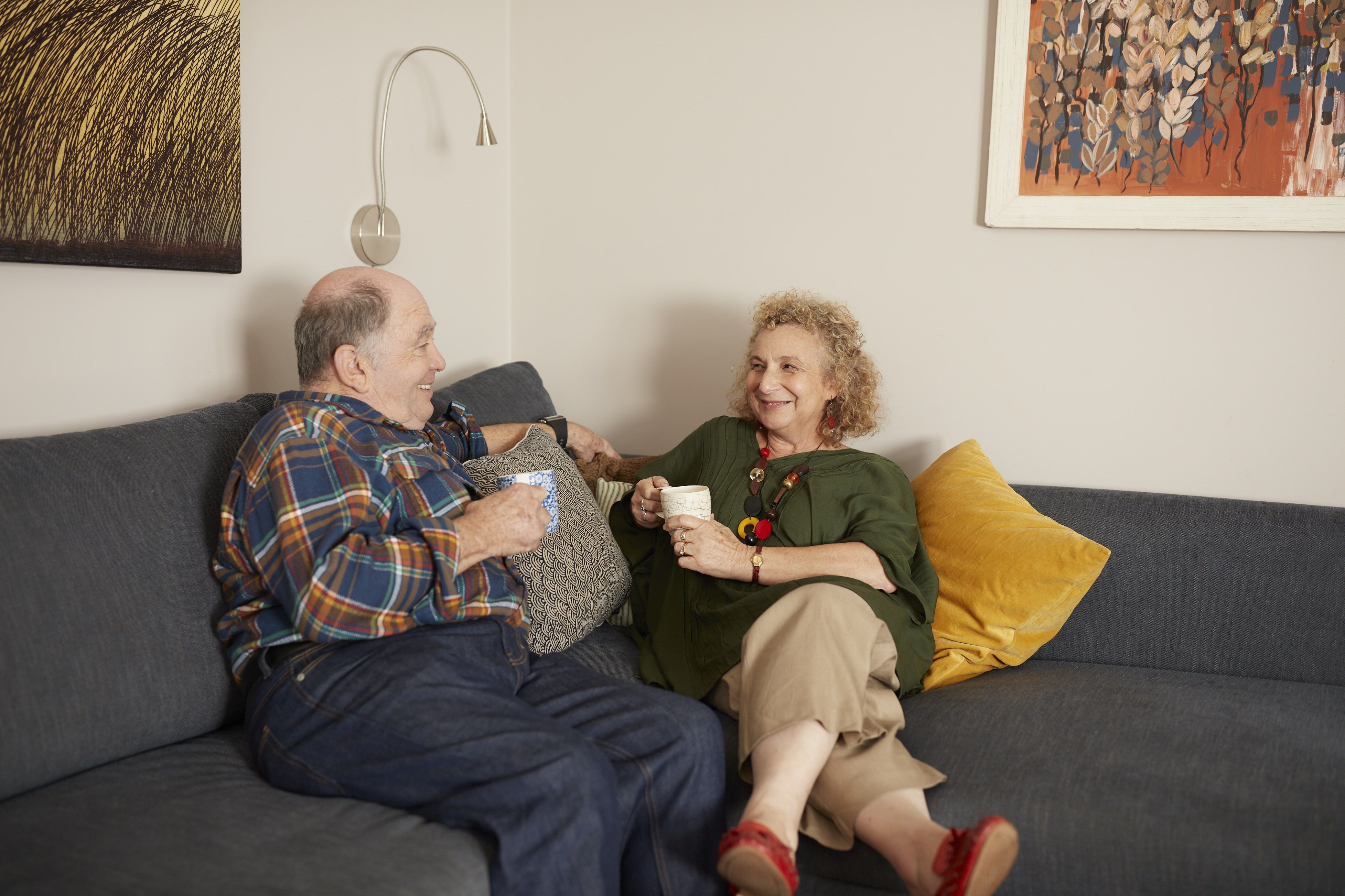 Couple sitting on a couch drinking a cup of tea