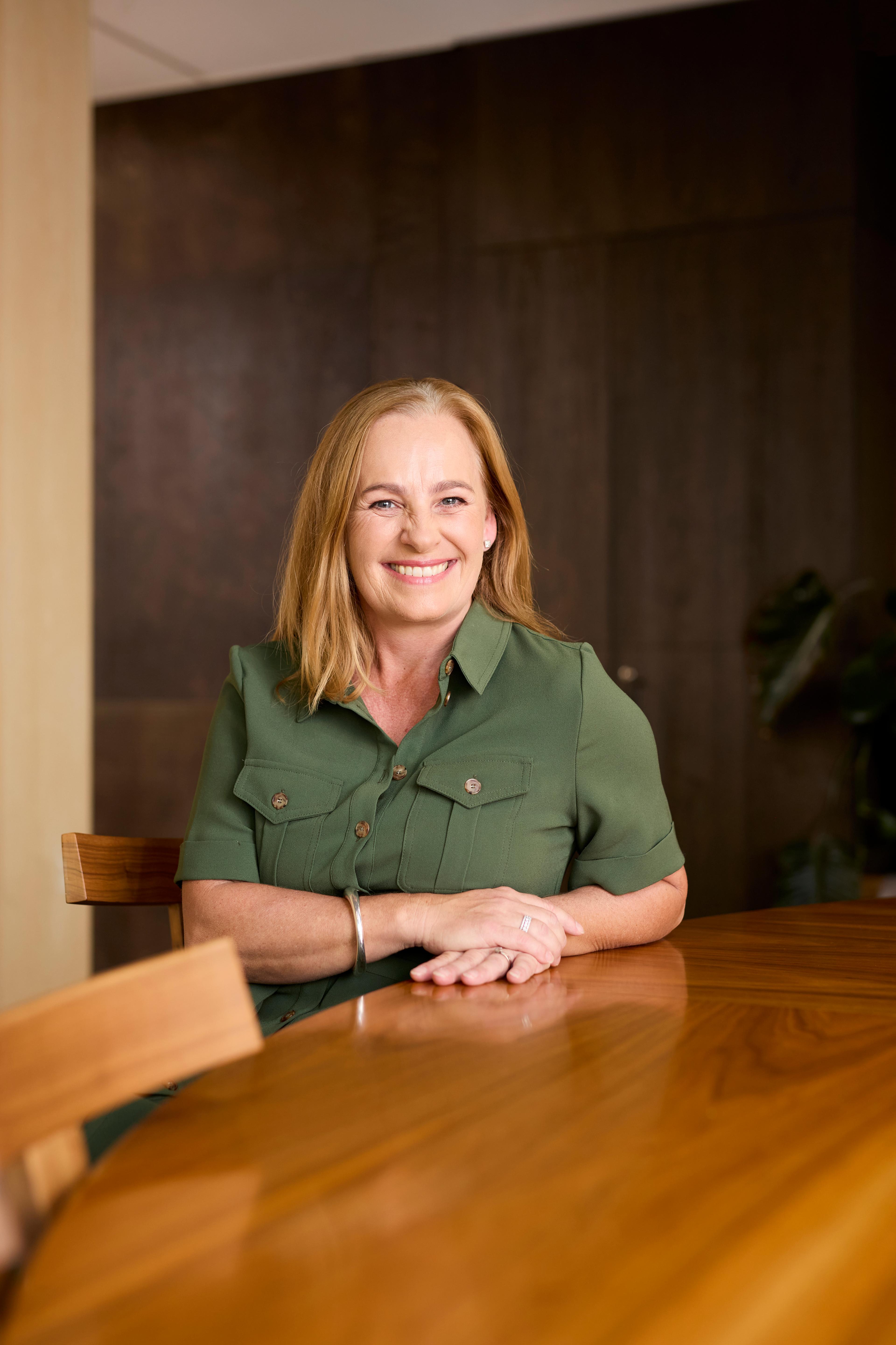 Woman sitting behind wooden table