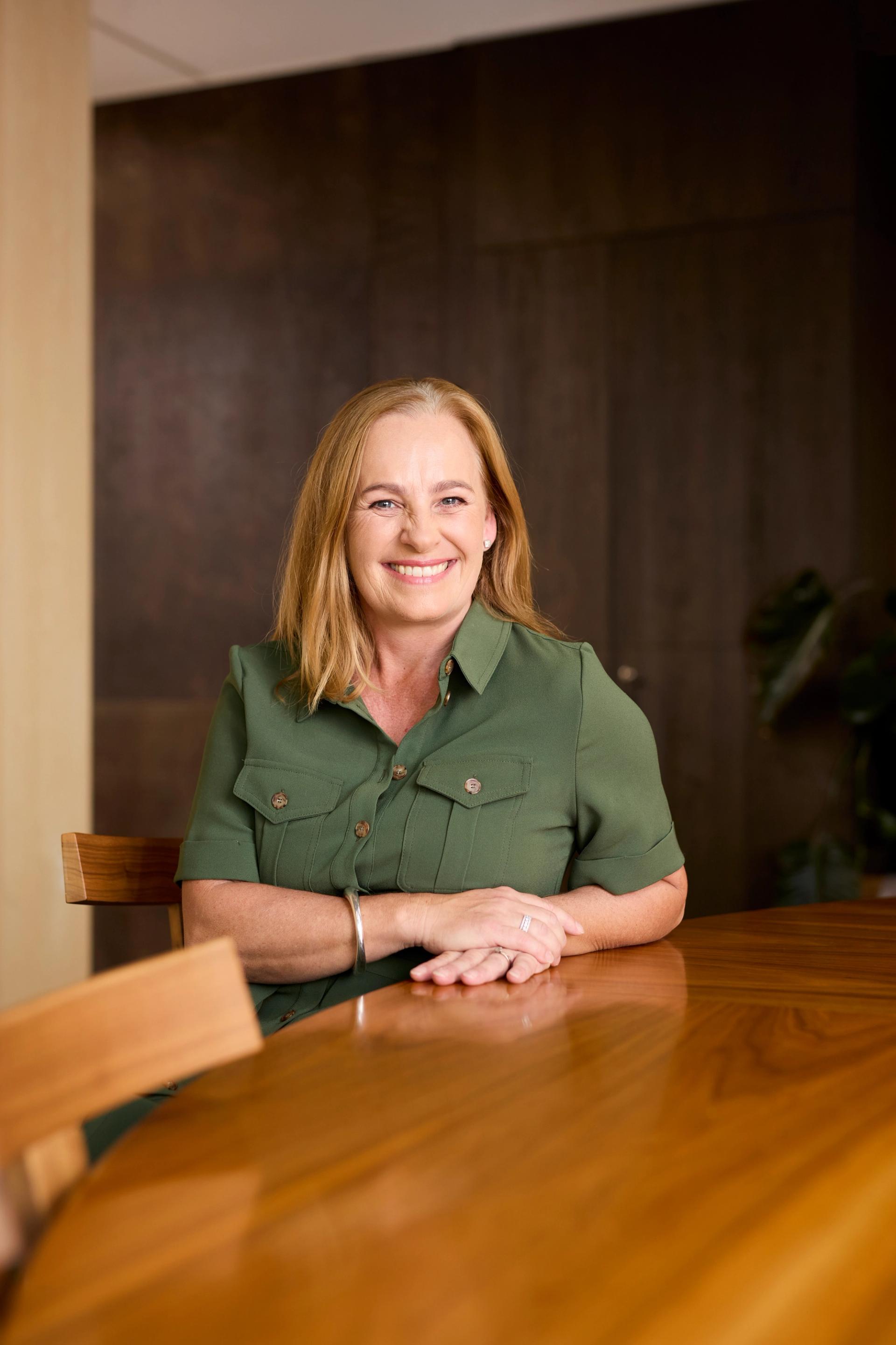 Woman sitting behind wooden table
