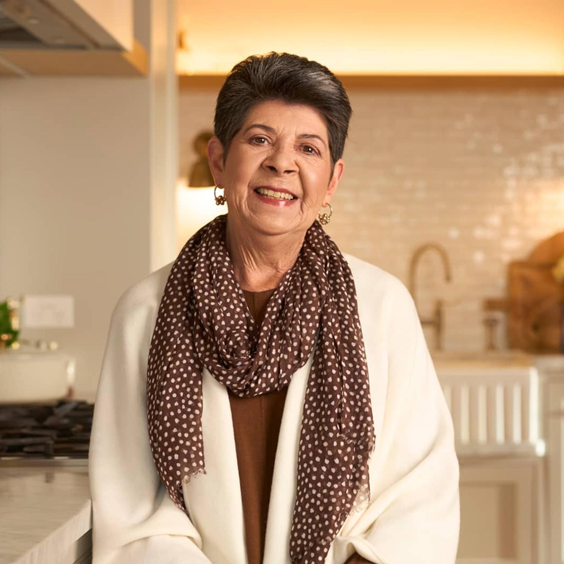 Woman sitting in kitchen smiling