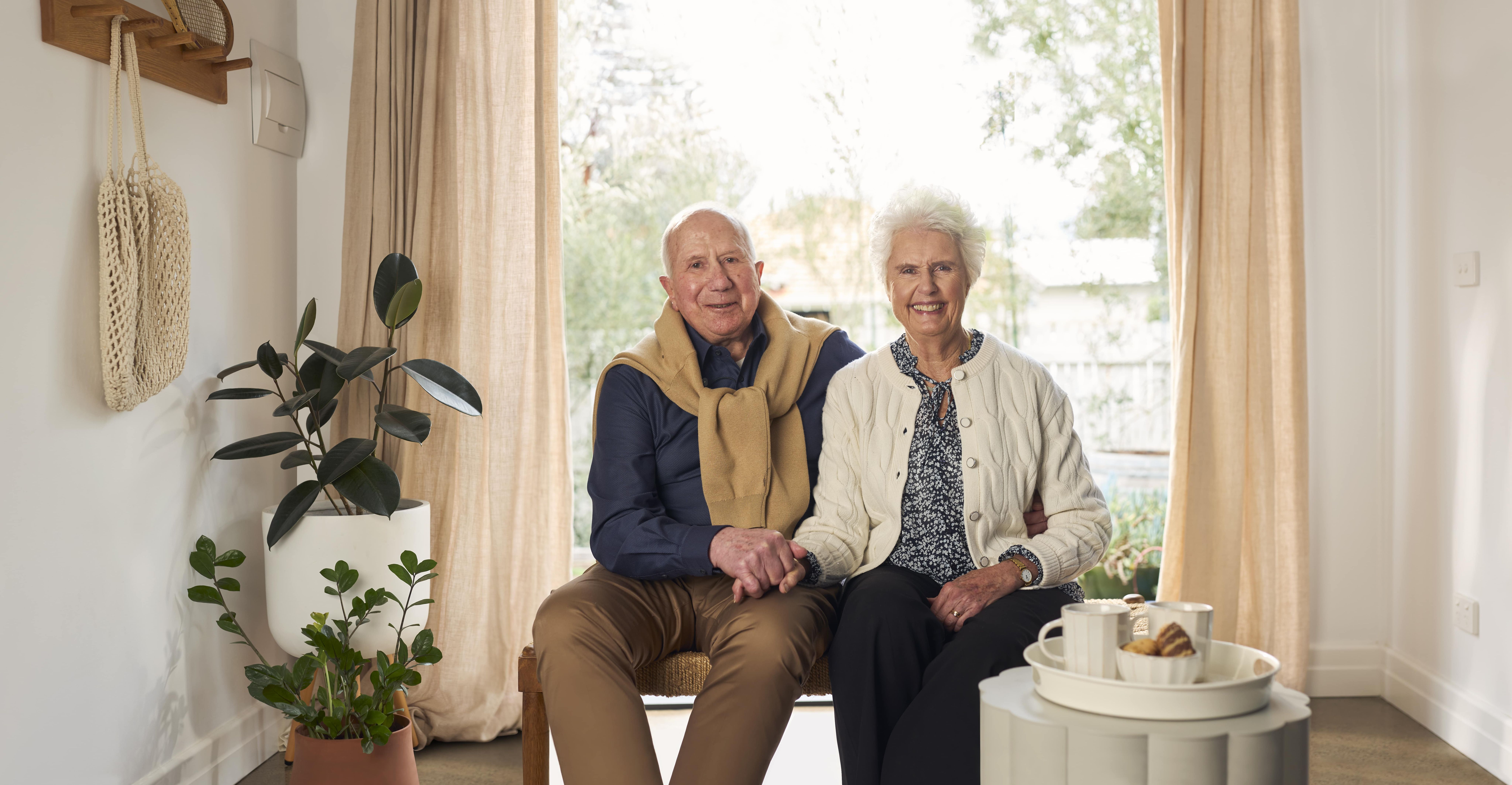 Couple sitting on a bench in front of a window