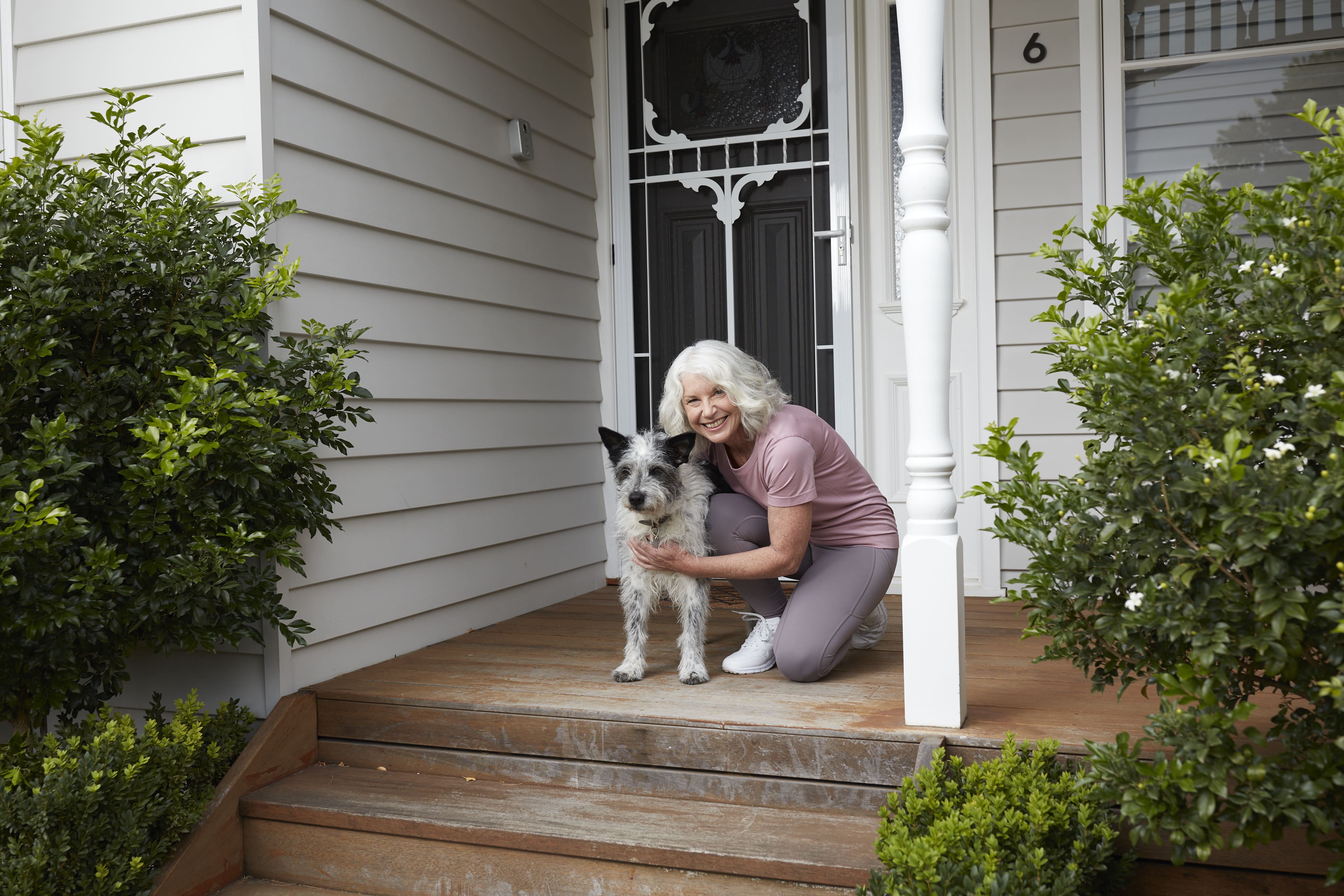 Woman in front of a house with a dog