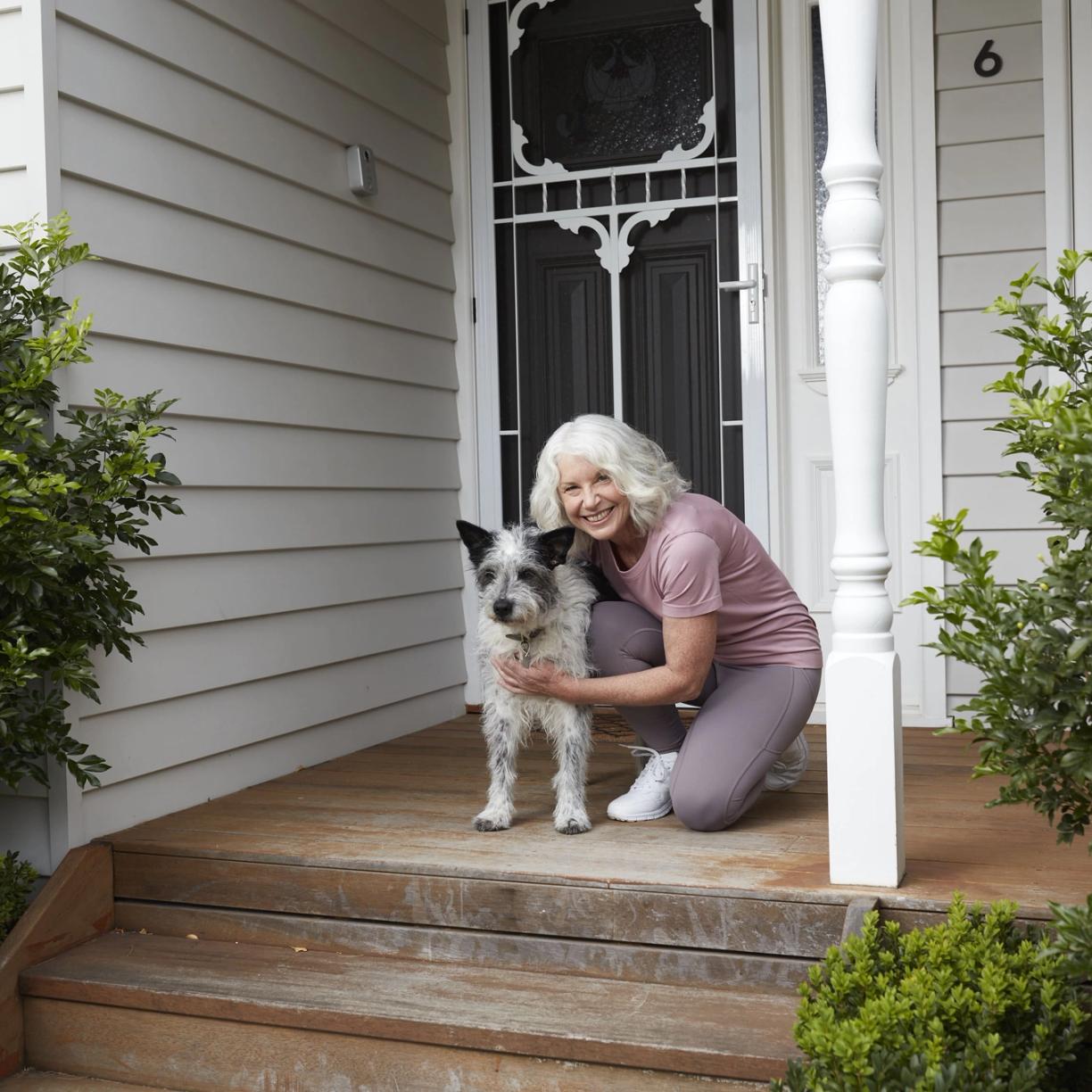 Woman in front of a house with a dog