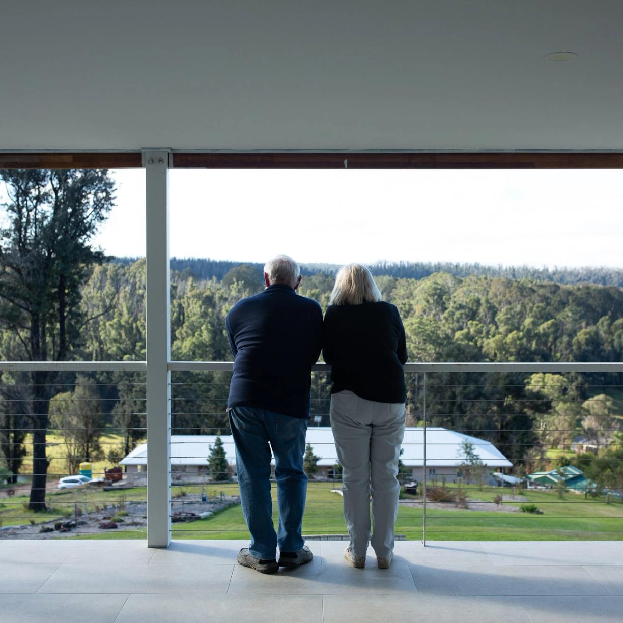 A couple look out at the view from their property