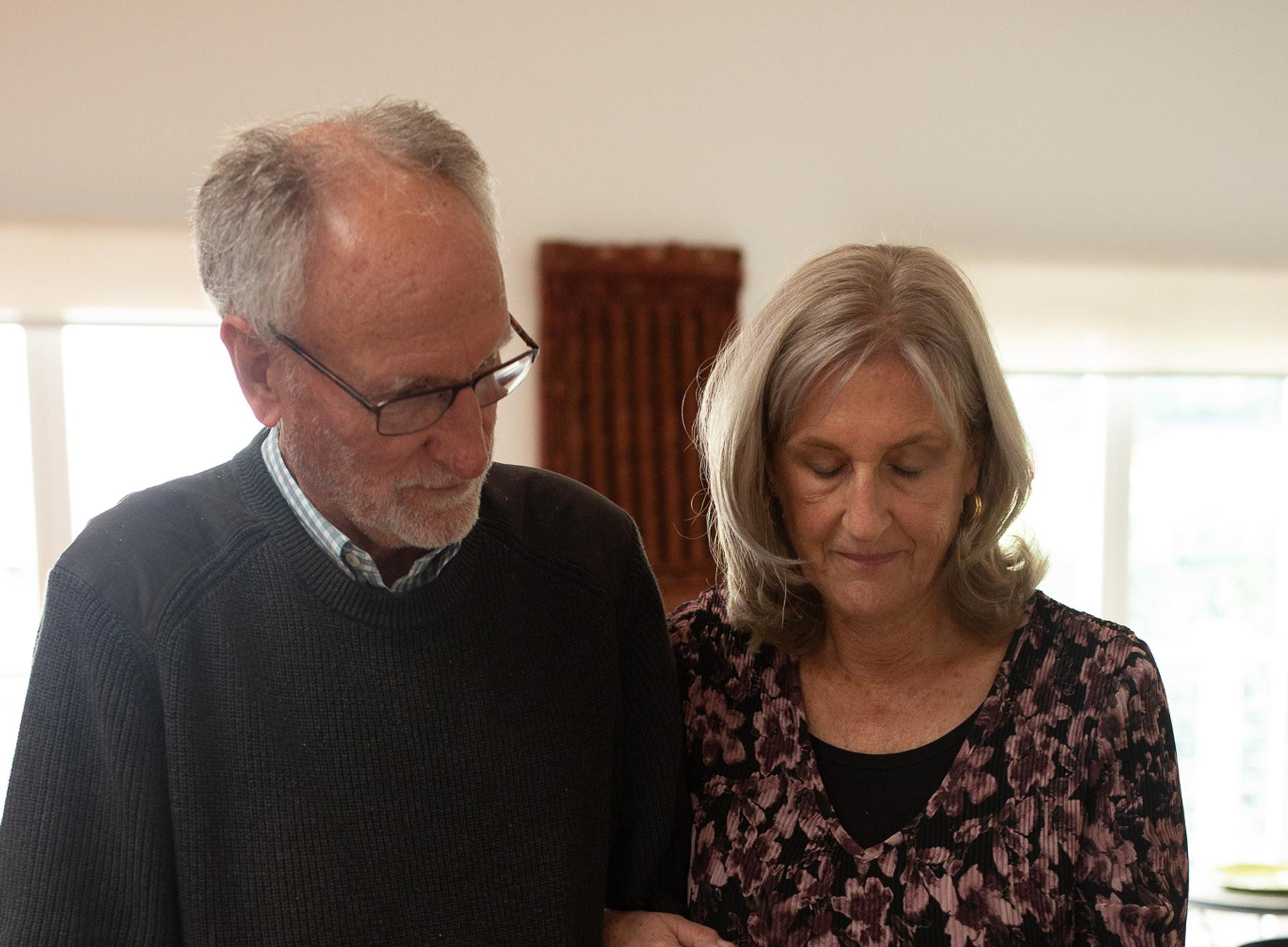 Couple standing by a table looking at photos