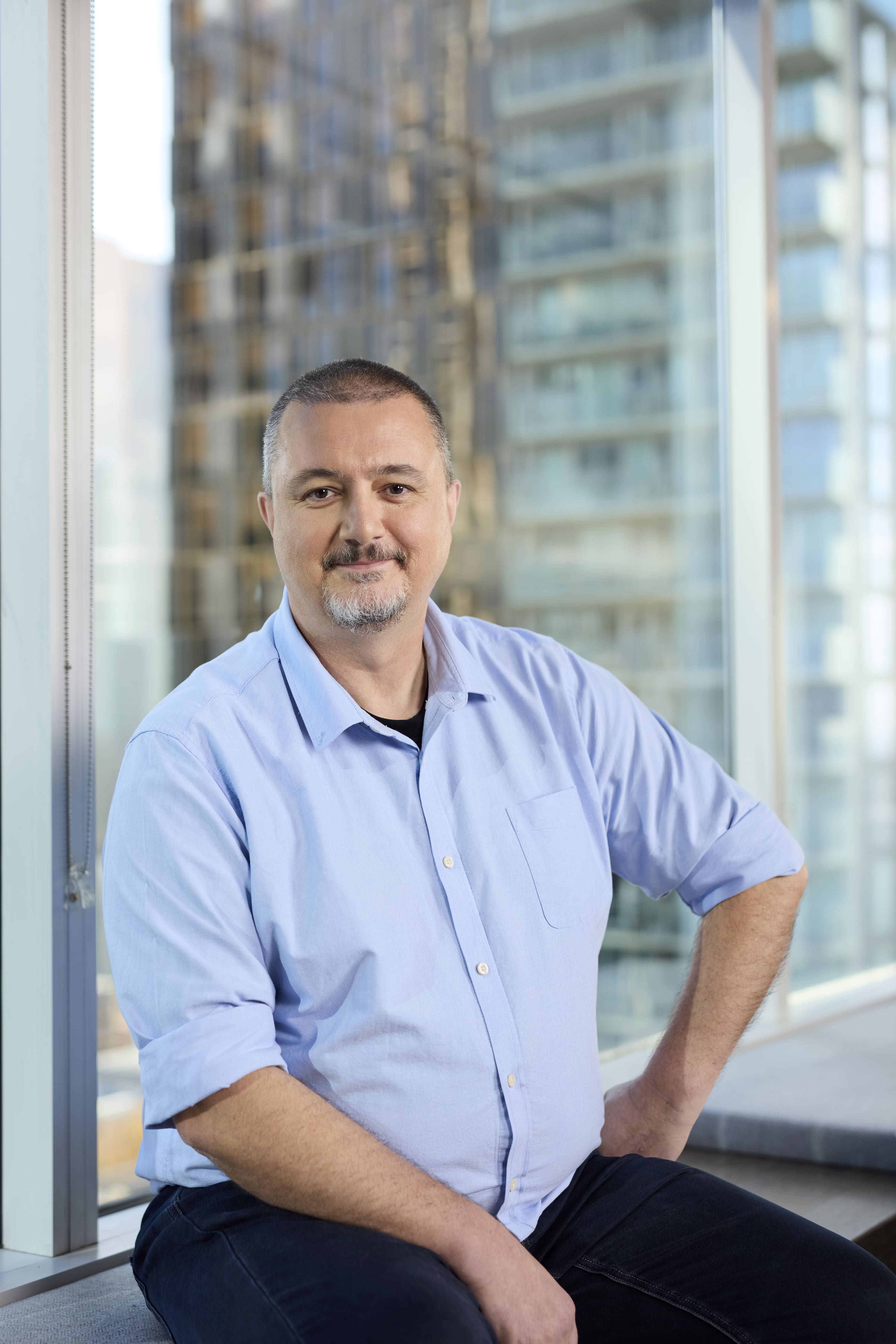 Image of man in from of an office window