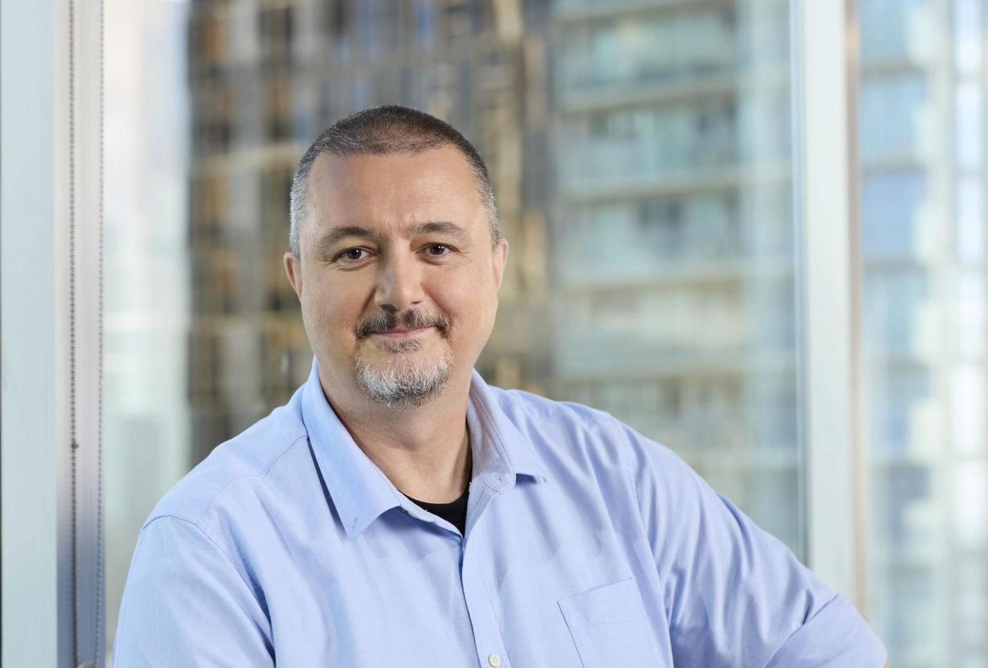 Image of man in from of an office window