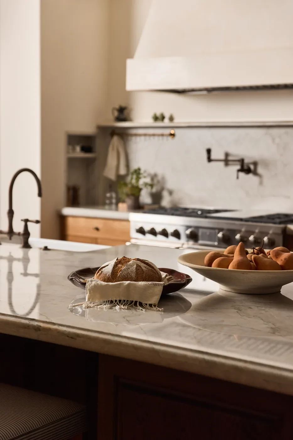 Kitchen with marble worktops and a brass range faucet