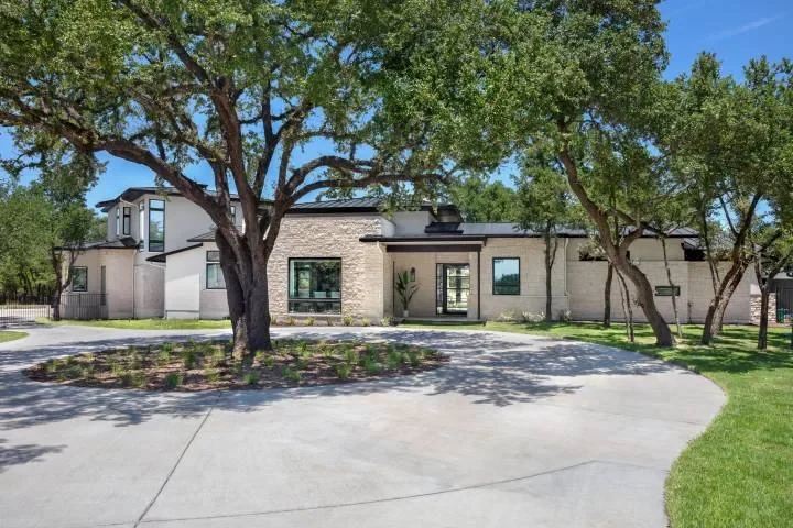 Contemporary home exterior with mature trees and a circular drive