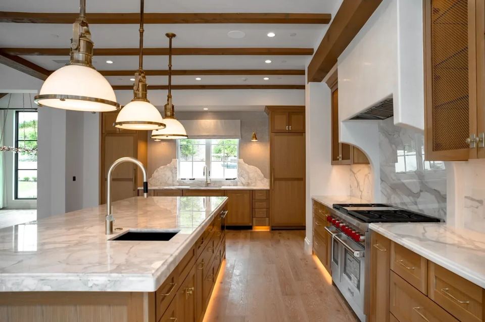 Kitchen with a marble island, wood cabinetry, and a range