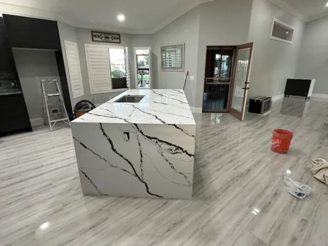 Modern Kitchen with Marble-Look Countertop and Sleek Cabinets in Spacious Room