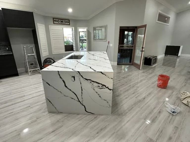 Modern Kitchen with Marble-Look Countertop and Sleek Cabinets in Spacious Room