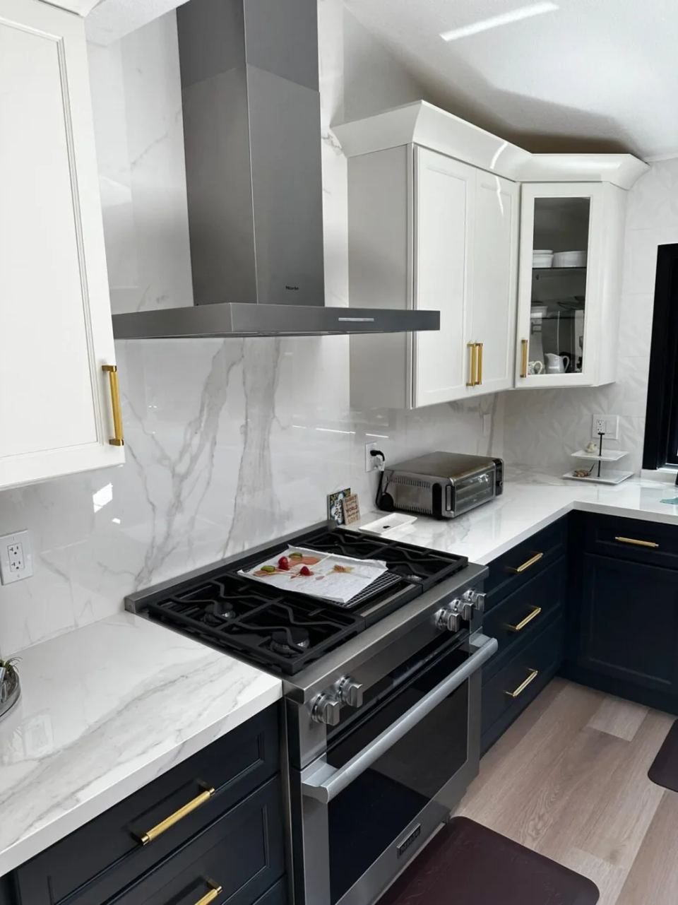 Kitchen with white cabinetry and dark countertops