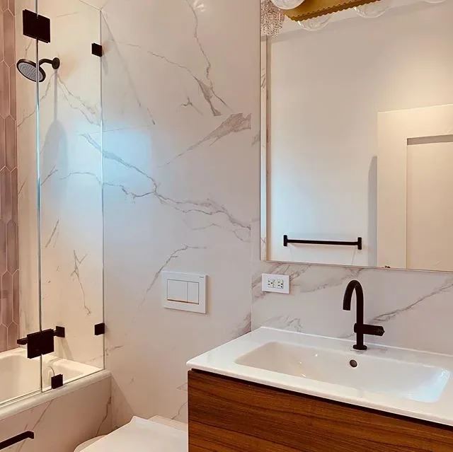 Bathroom with marble tile, a wood vanity and wall-mounted faucet
