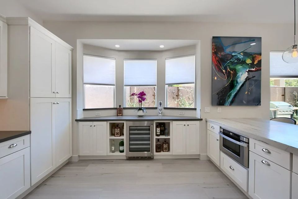 Modern Kitchen Featuring White Cabinets and Granite Countertops with Artistic Decor