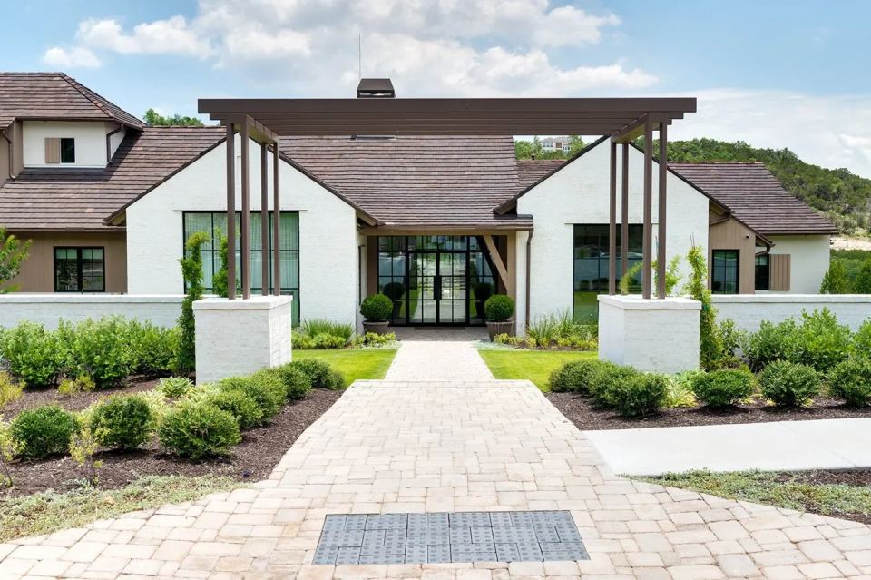 Custom-home entrance with white masonry and landscaped grounds
