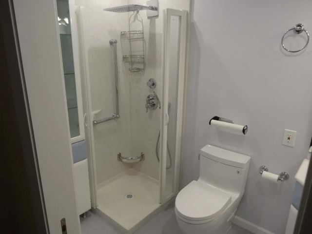 Finished bathroom with a tiled shower and glass enclosure
