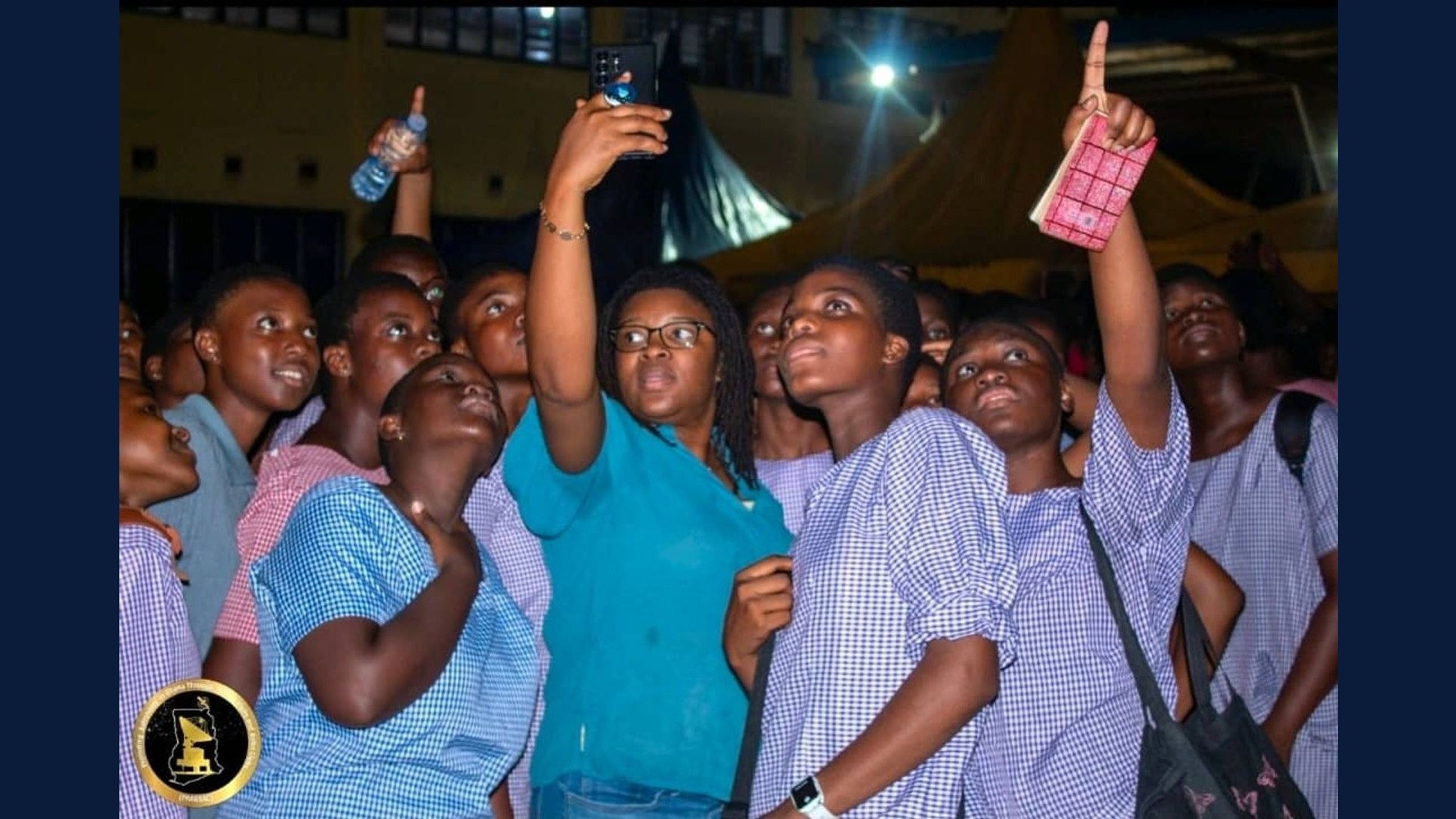 Students reach for the sky, capturing the moment during a night outreach event.