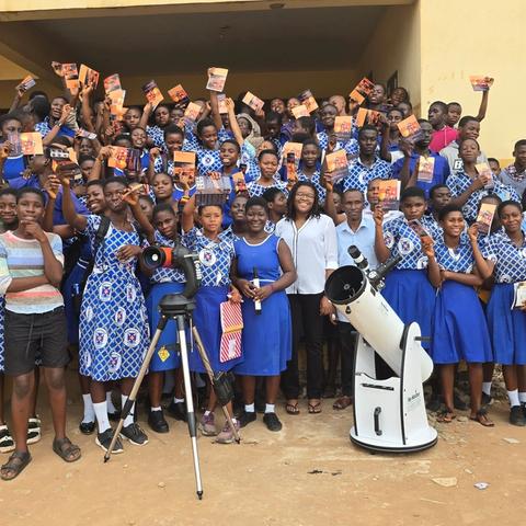 A school group poses with their telescope after a daytime observation session.