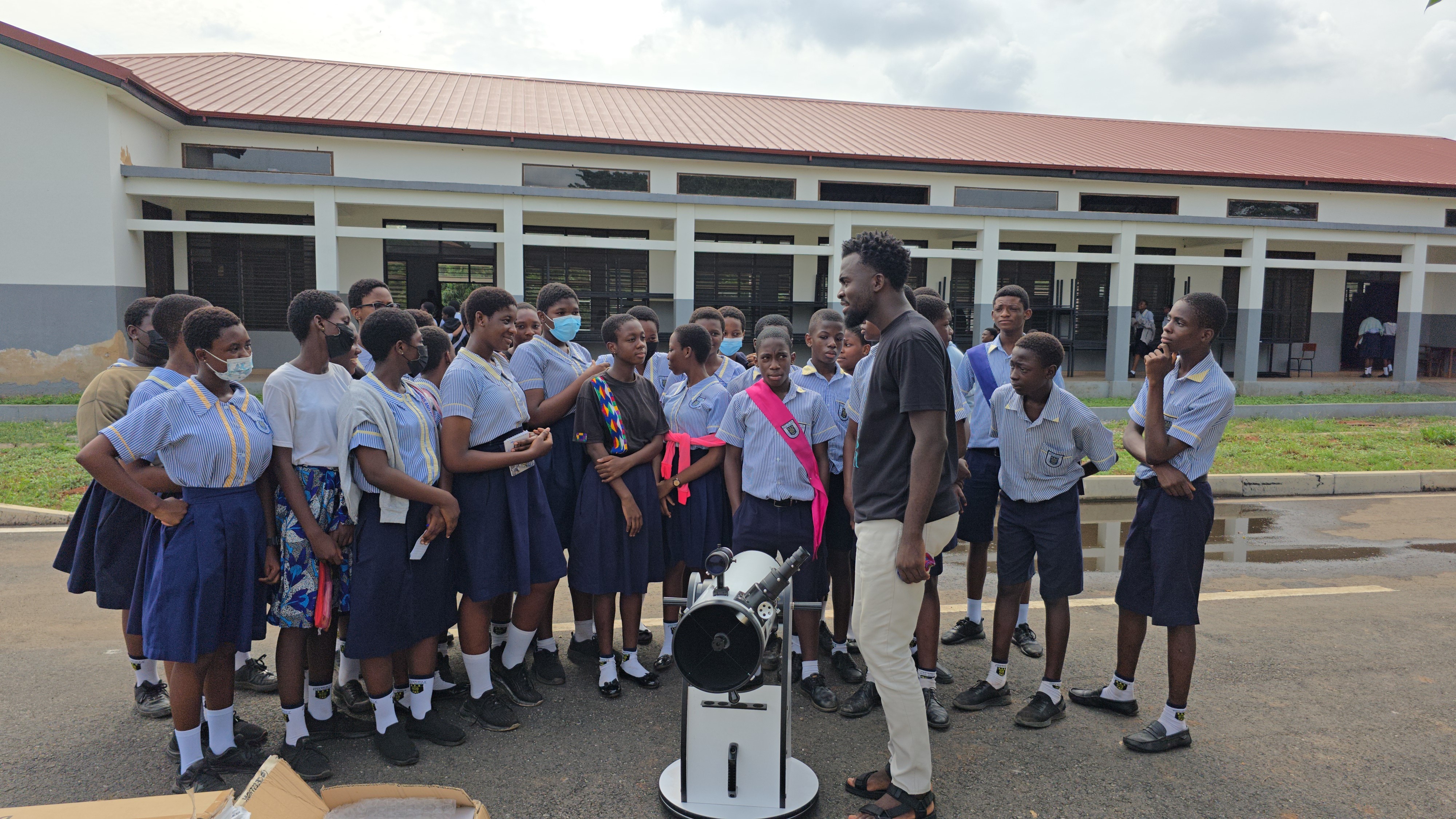 Schoolchildren gather around the telescope during an outreach visit.