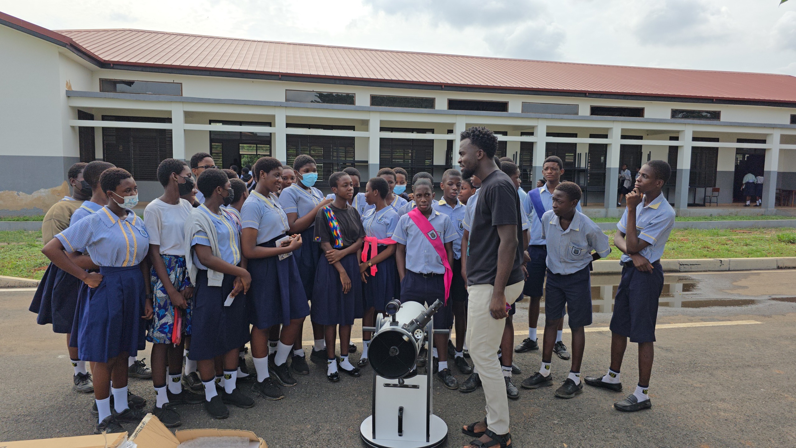 Schoolchildren gather around the telescope during an outreach visit.