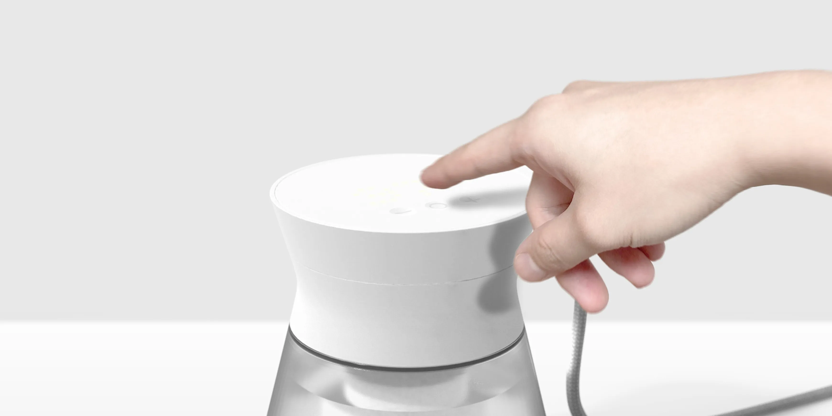 A Hand reaching out to press a button on the Intoku smart water kettle