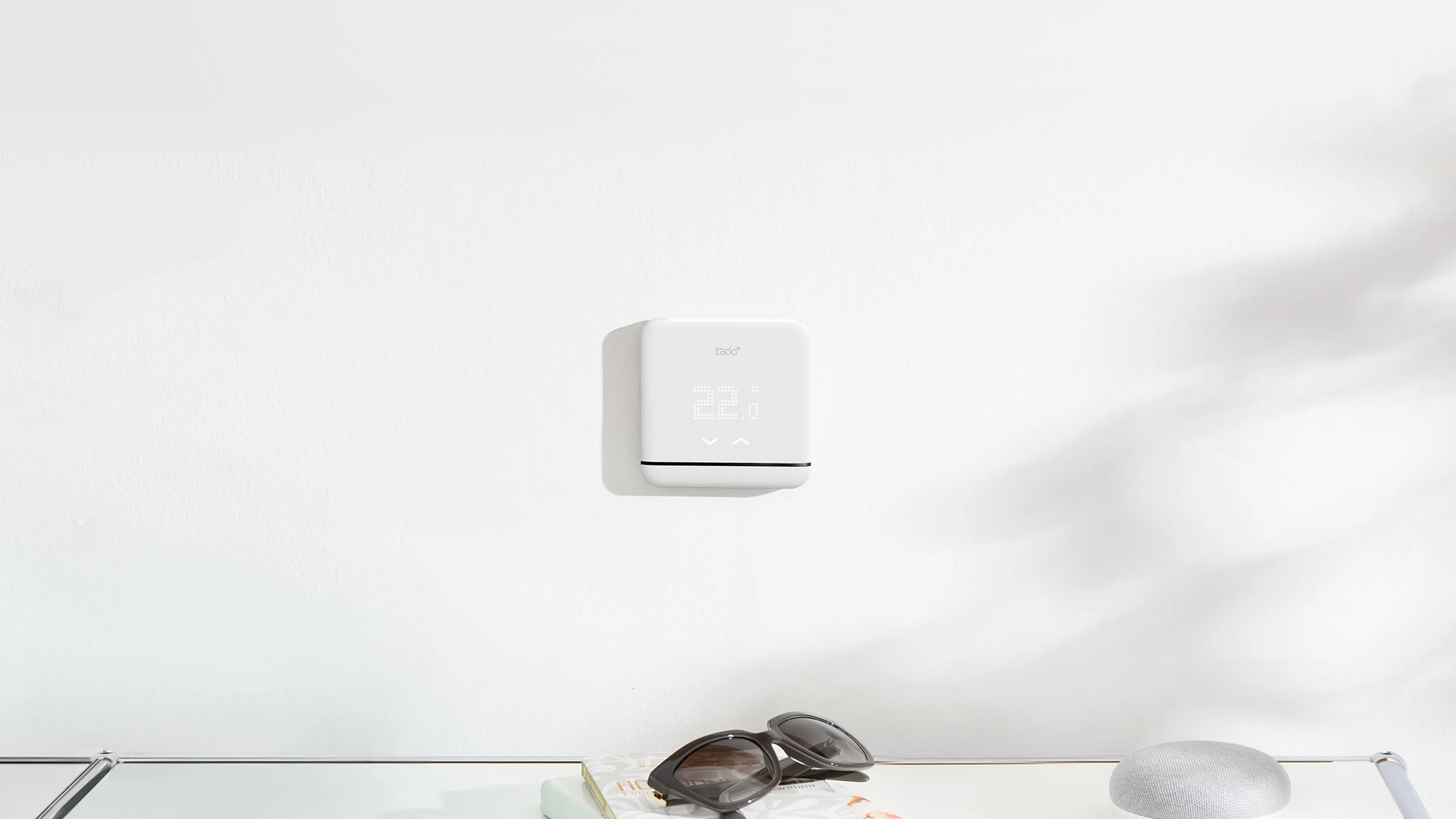 Tado smart ac control mounted on a wall over a sideboard
