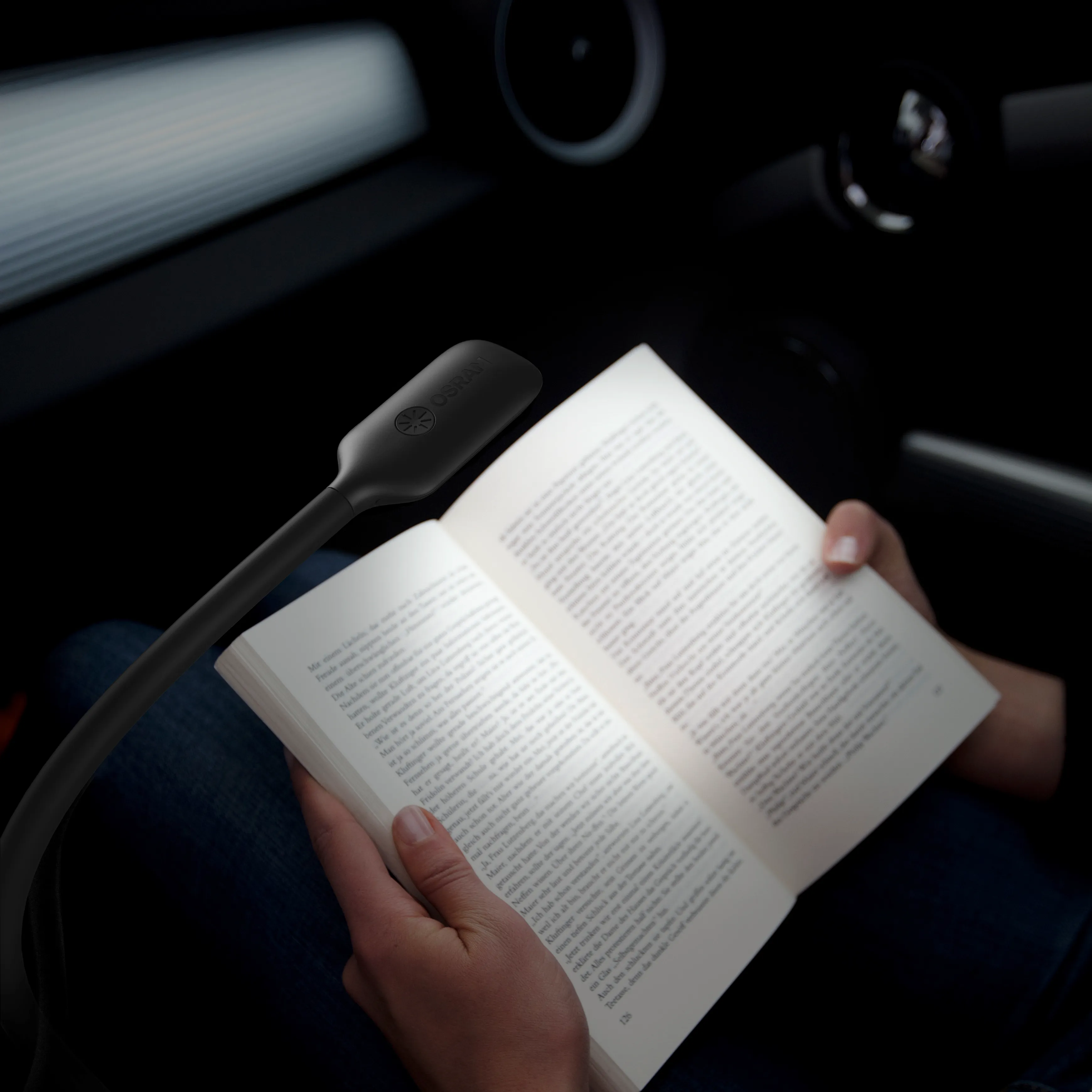 A osram passenger lamp in a car illuminating a book